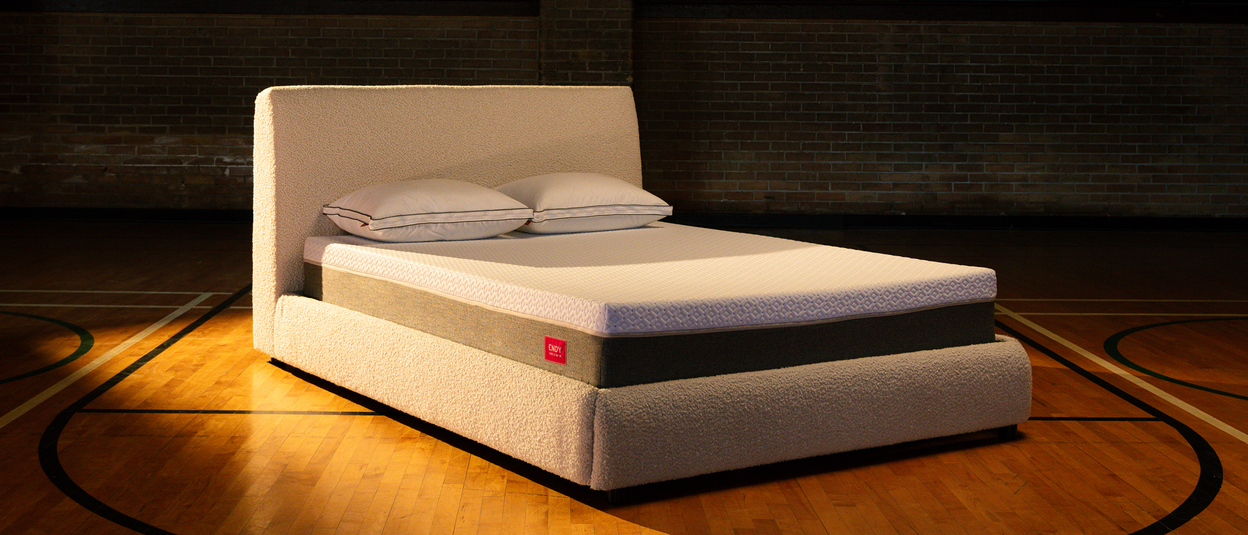 Bare Endy Hybrid mattress on a white upholstered bedframe on a basketball court