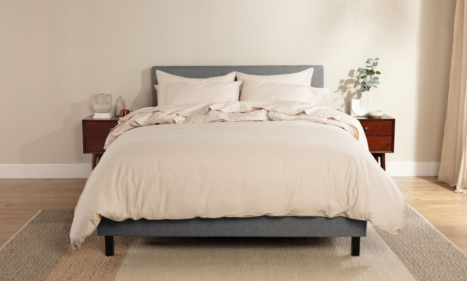 A Endy bed dressed with beige percale cotton sheets and a plush duvet with matching cover