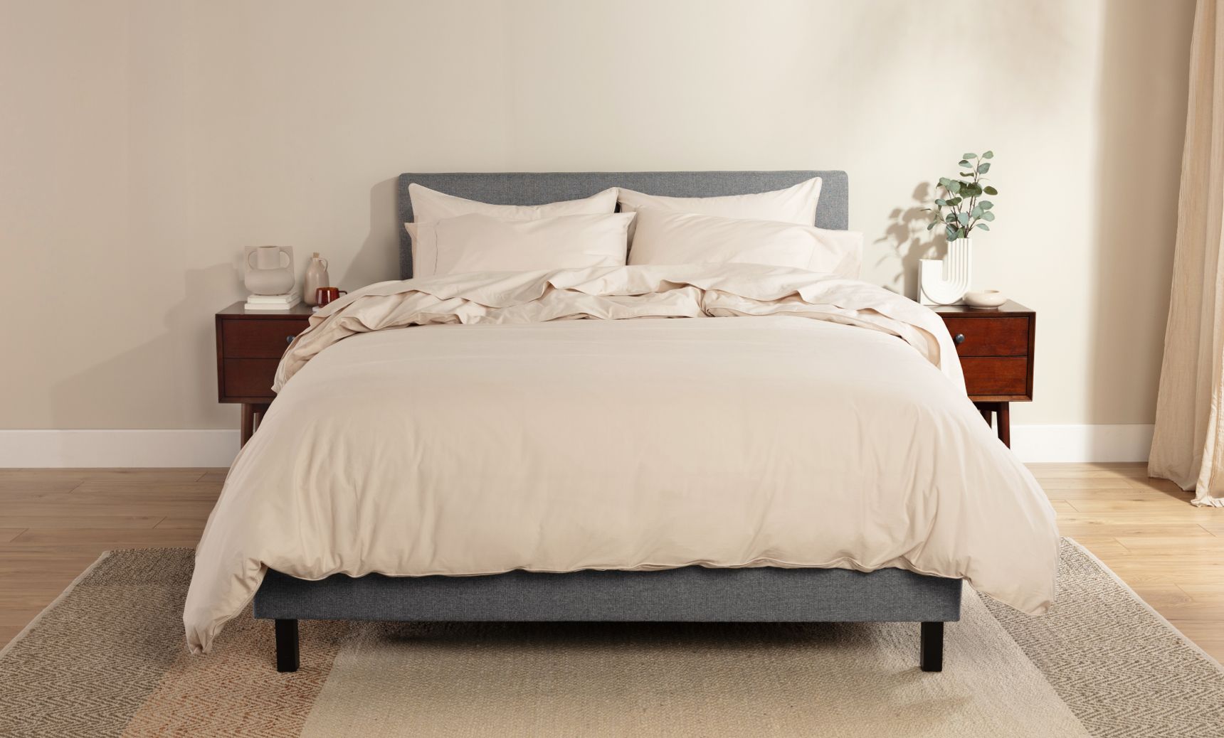A Endy bed dressed with beige percale cotton sheets and a plush duvet with matching cover