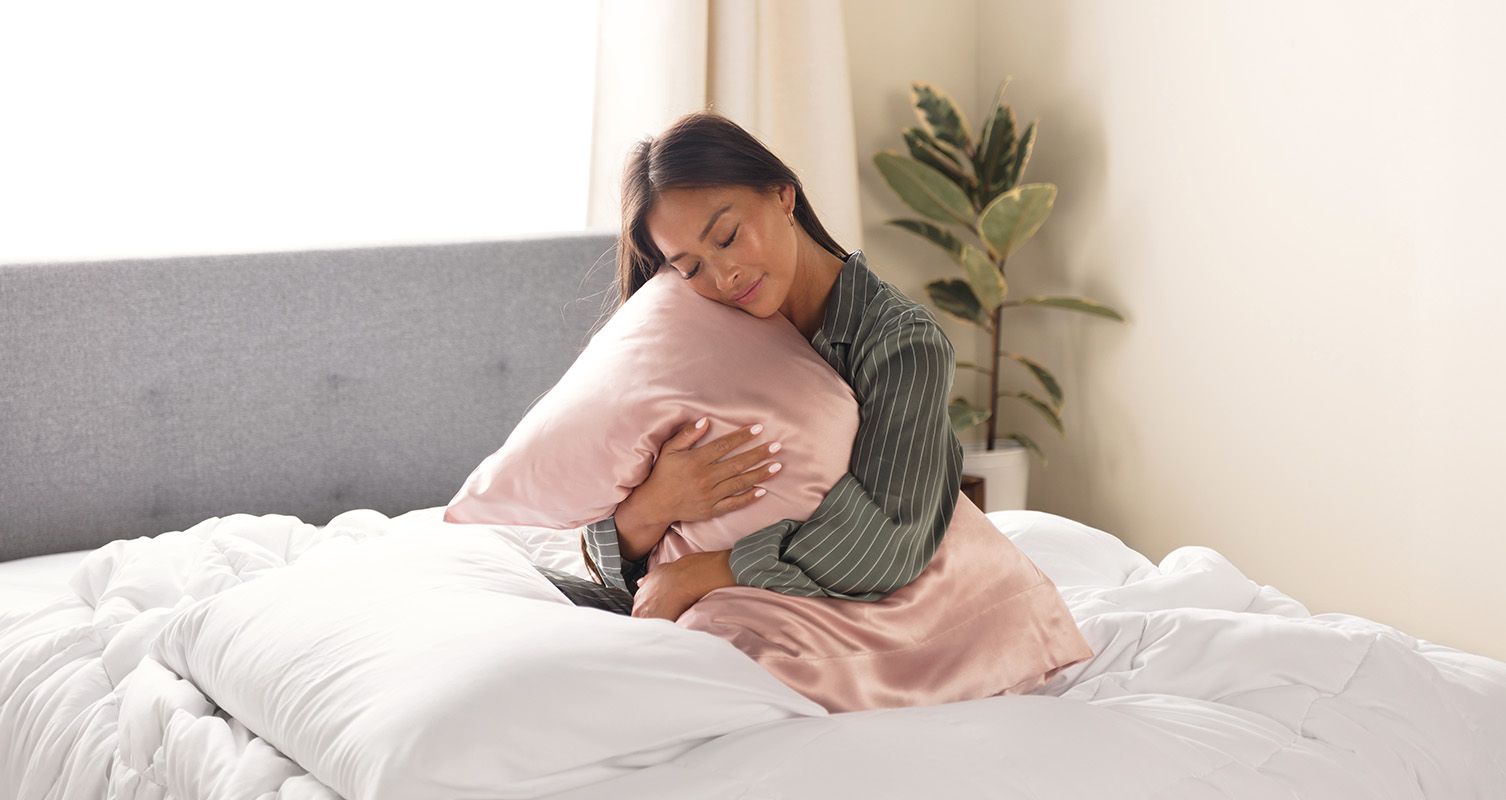 Woman hugging a pillow wrapped in an Endy Silk Pillowcase