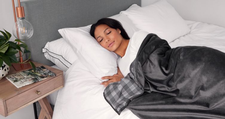 A person snoozing in bed with an Endy Weighted Blanket.