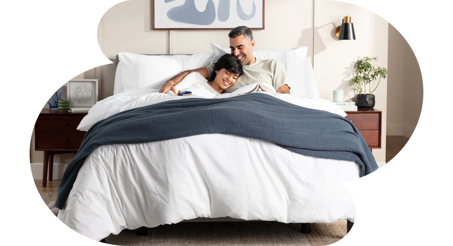 Two people relaxing on an Endy Mattress outfitted with Endy's collection of sleep products.