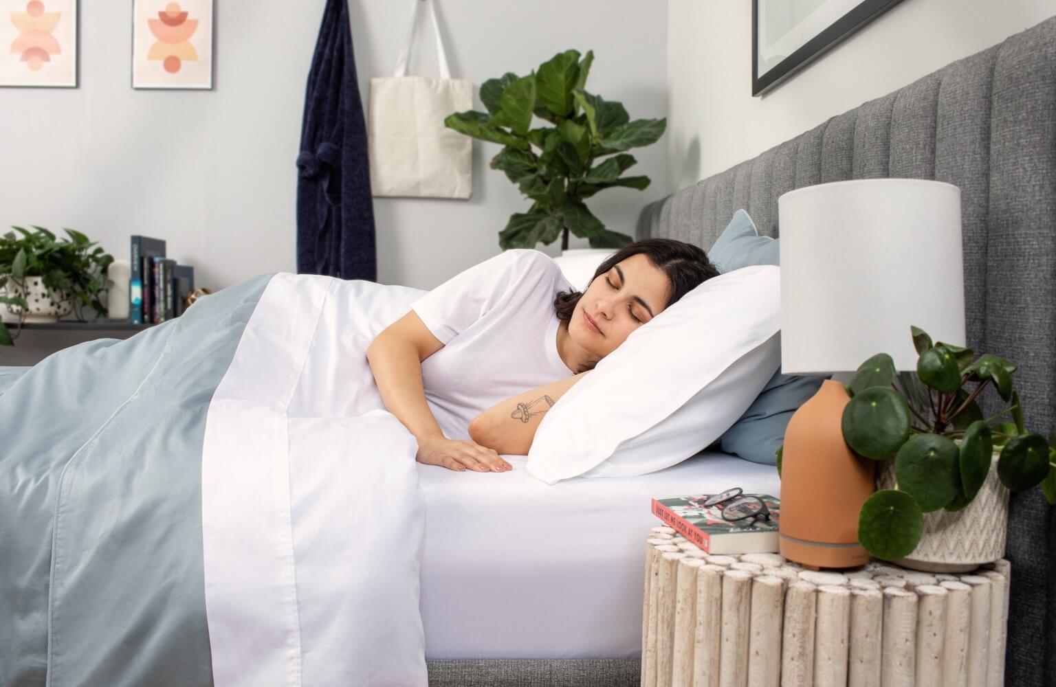 A person sleeping comfortably with the Alpine White Organic Cotton Sheets. 