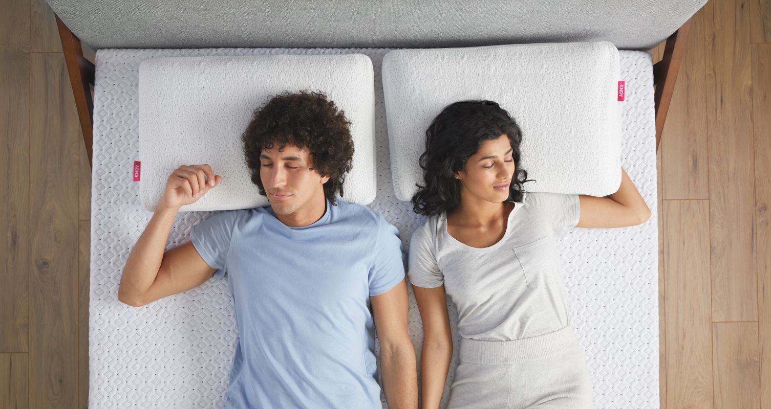 Two people snoozing on an Endy Mattress with Endy Memory Foam Pillows.