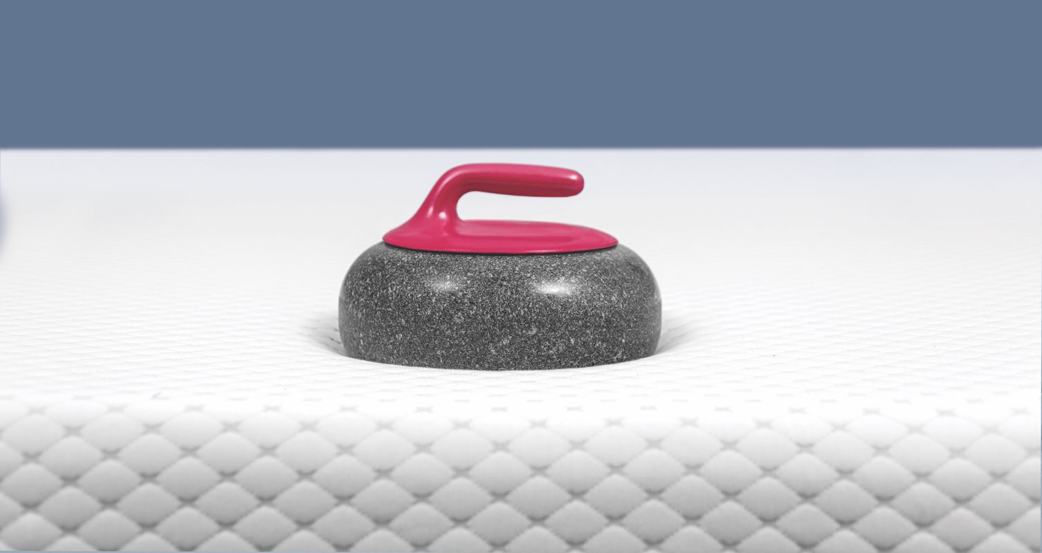 A curling stone resting on top of an Endy Mattress.