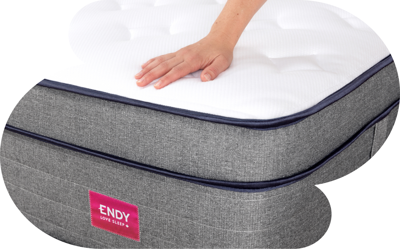  A person's hand resting on the Endy Hybrid Mattress.