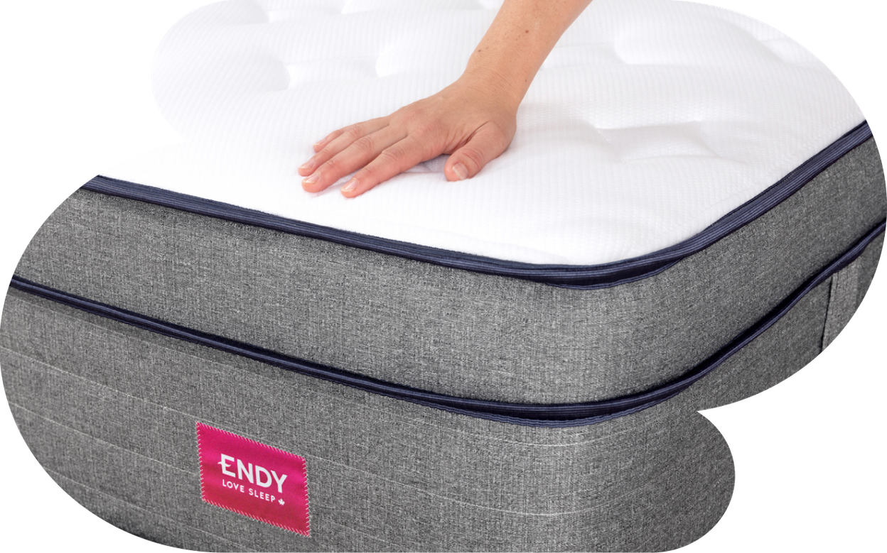  A person's hand resting on the Endy Hybrid Mattress.