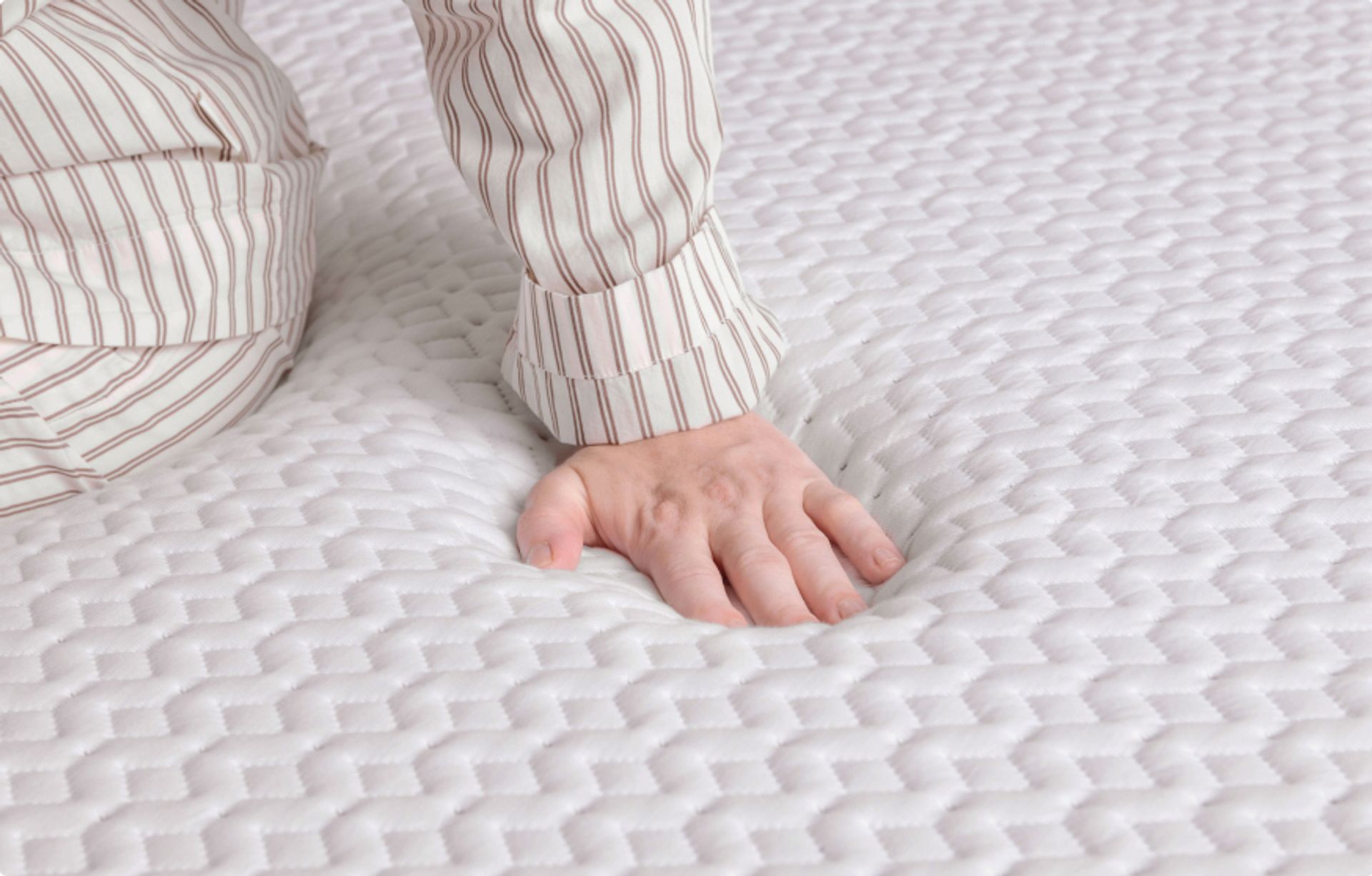 Close up of the surface of the mattress, a hand pushes on it
