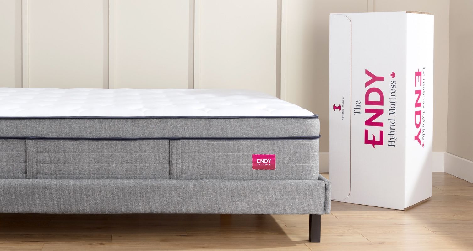 An Endy Hybrid Mattress sitting next to its box