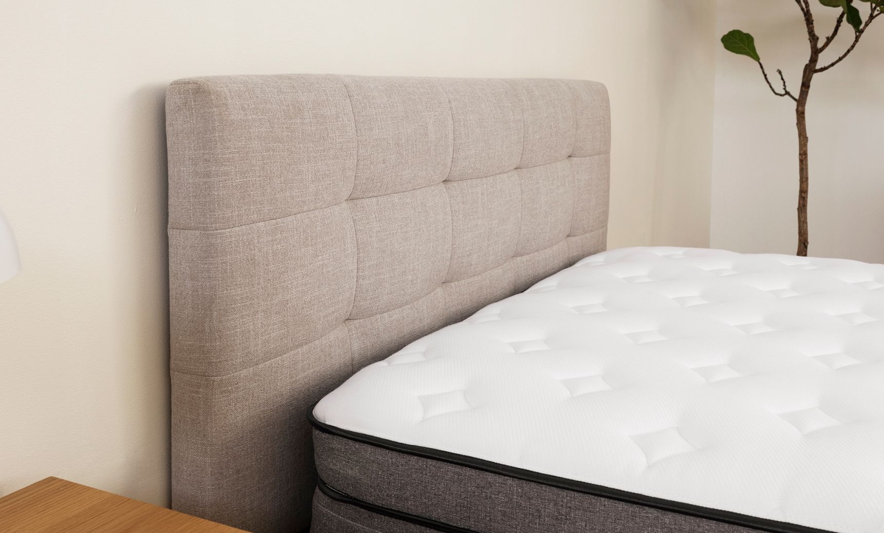 Close-up of the tufted upholstered headboard, and the Endy Hybrid Mattress.