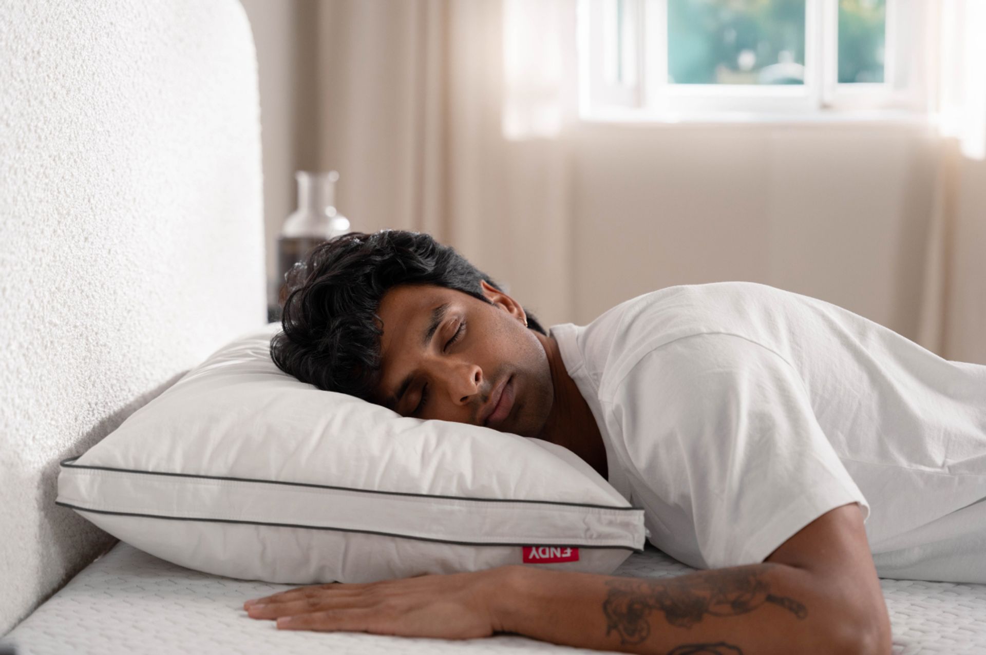 Man sleeping on his stomach with an Endy Customizable Pillow under his head