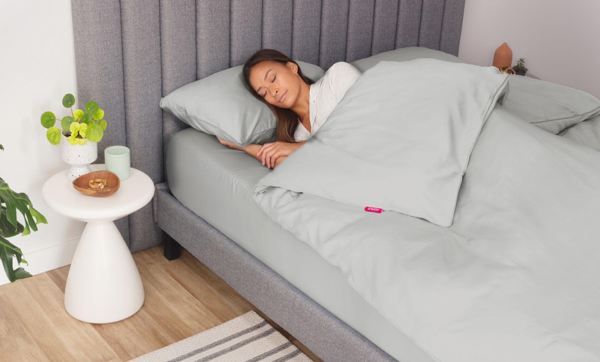 Woman sleeping in a bed under a fog grey Endy Duvet