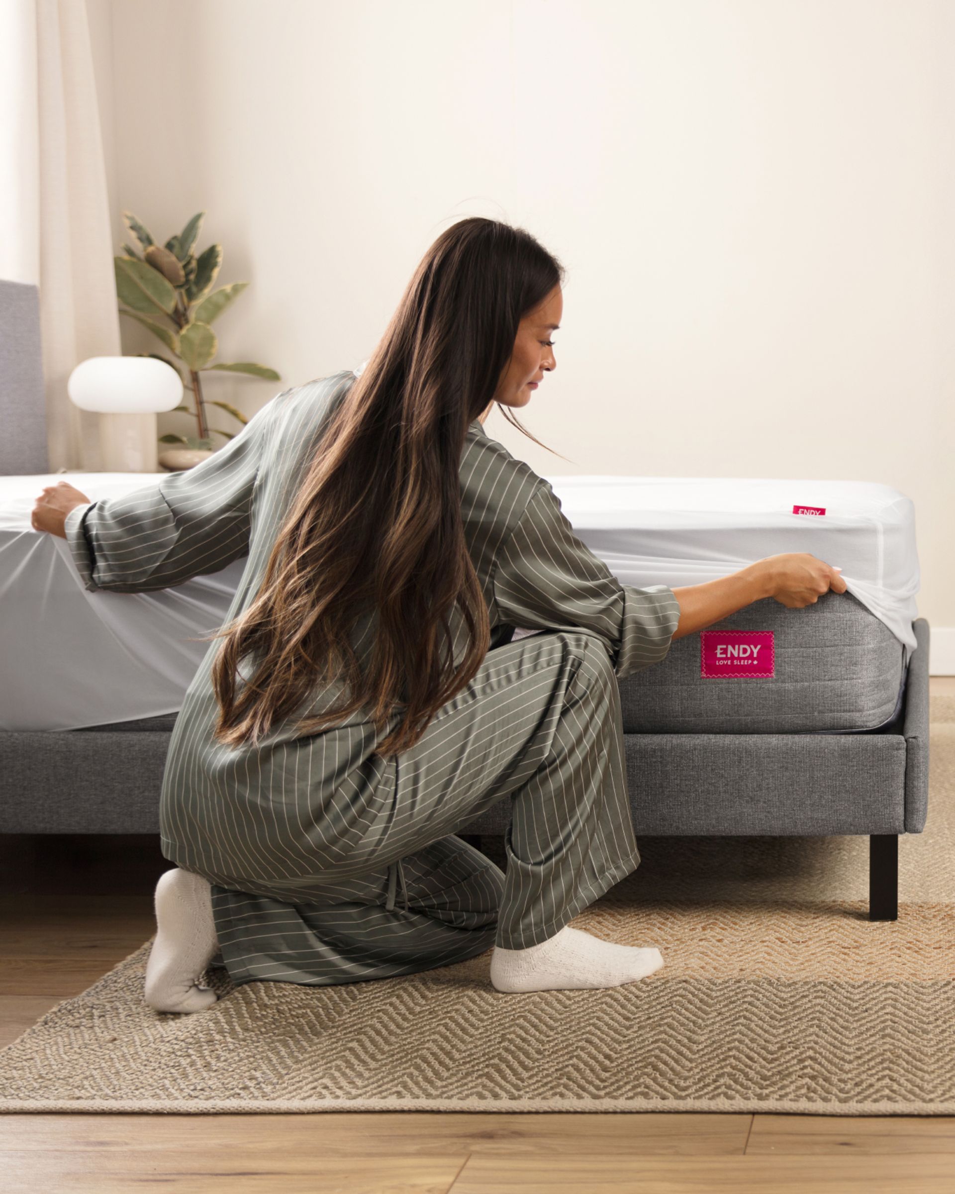 A person making a bed with The Endy Everyday Sleet Set.