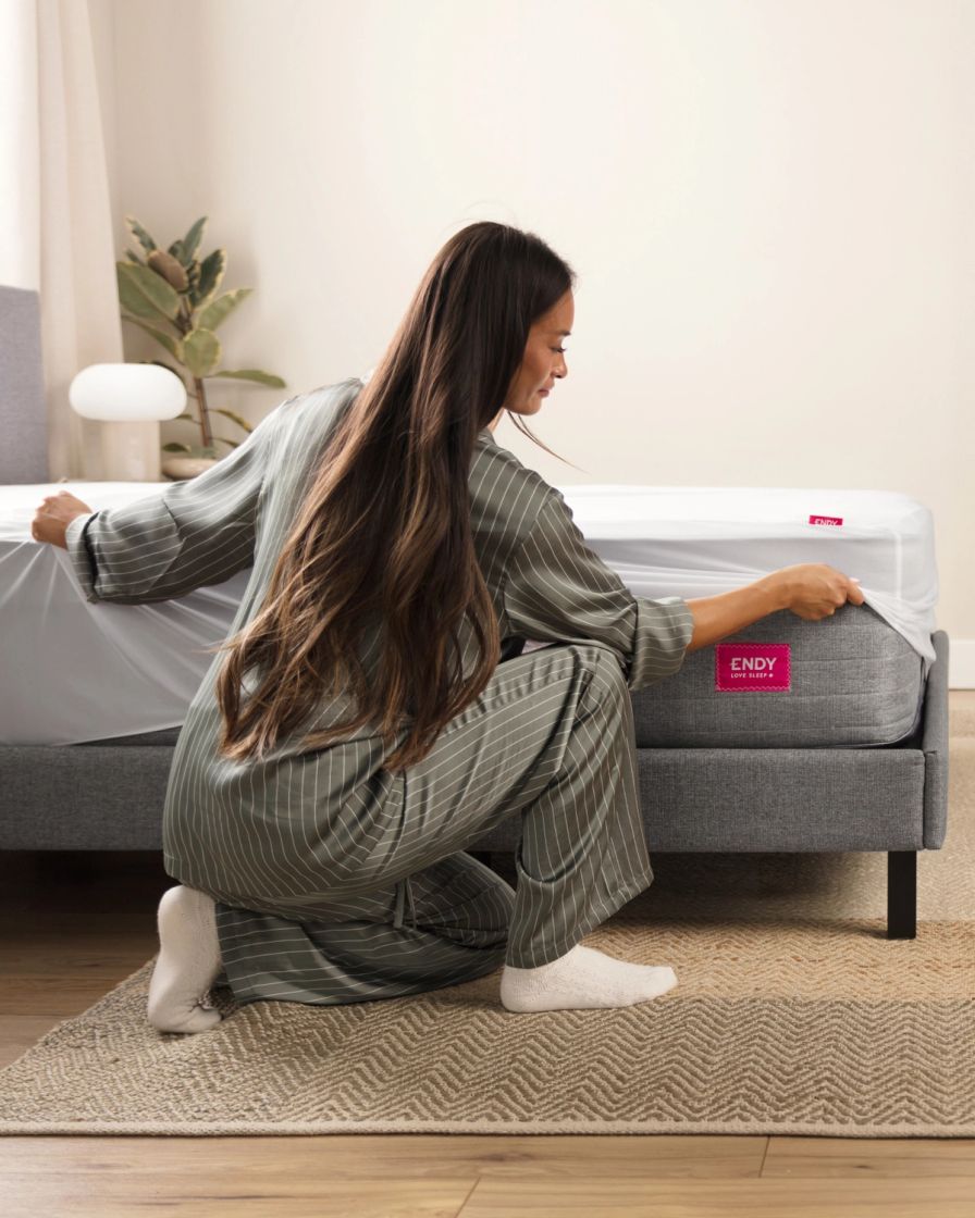 A person making a bed with The Endy Everyday Sleet Set.