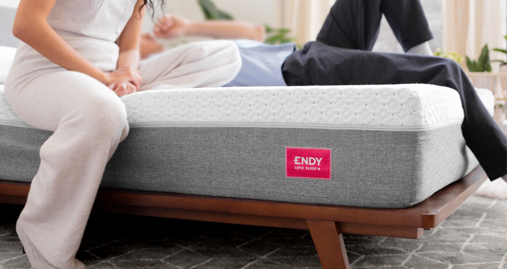 Close up of the front corner of the Endy Mattress, a man and woman are lying on the mattress