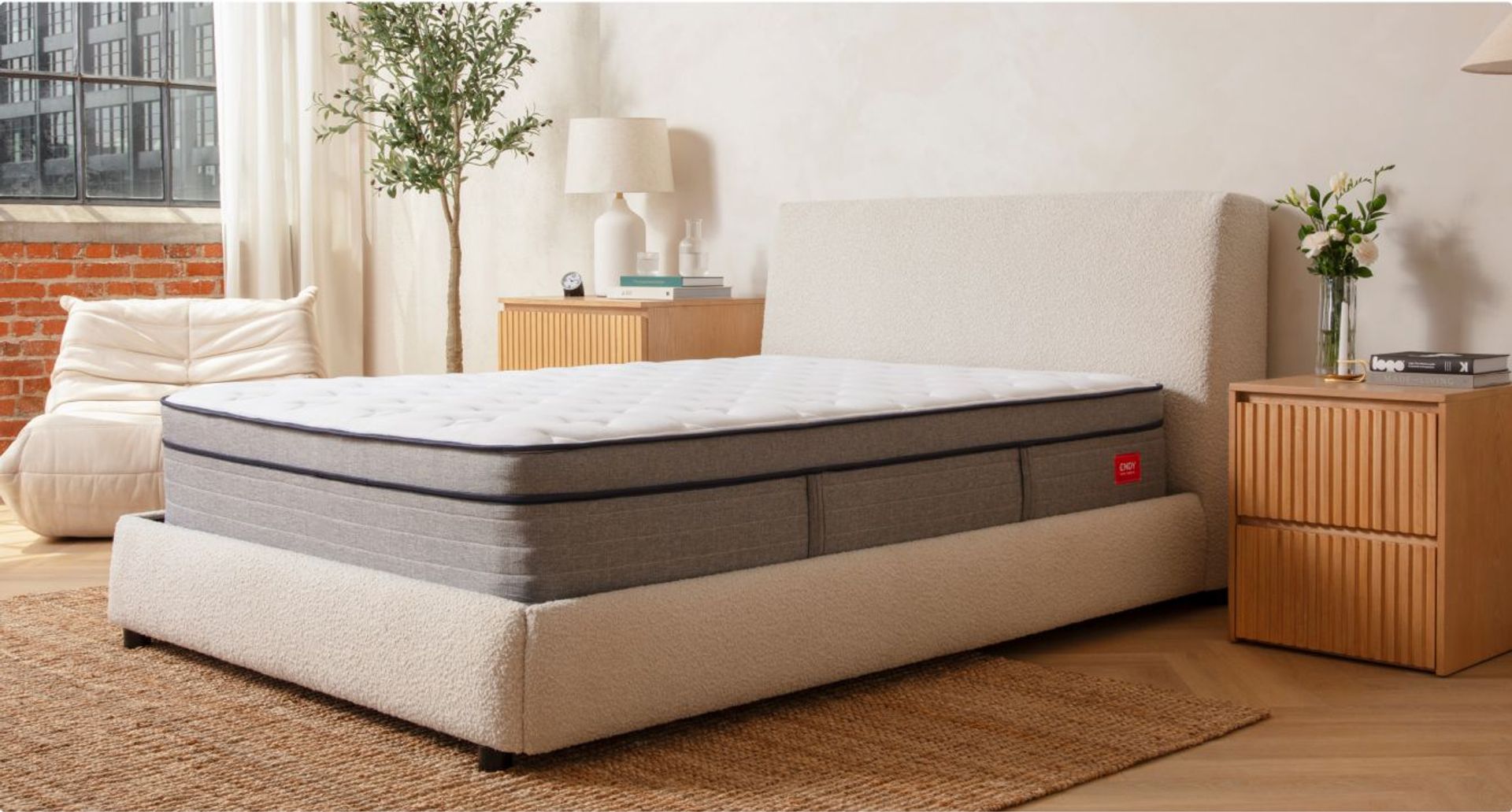 Bare Endy Hybrid mattress on a white upholstered bed frame in a beige bedroom