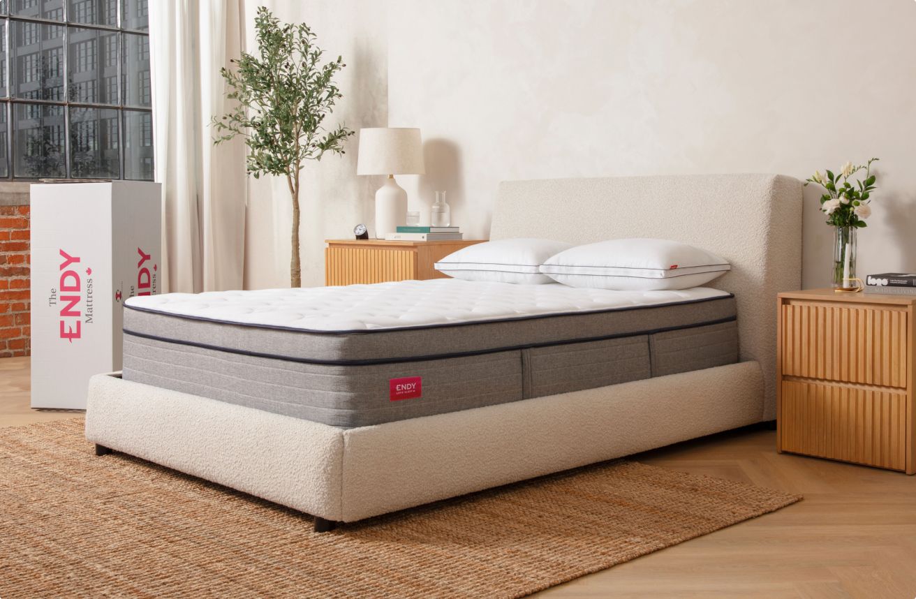 Bare Endy Hybrid mattress on a white bed frame in a minimalist beige bedroom