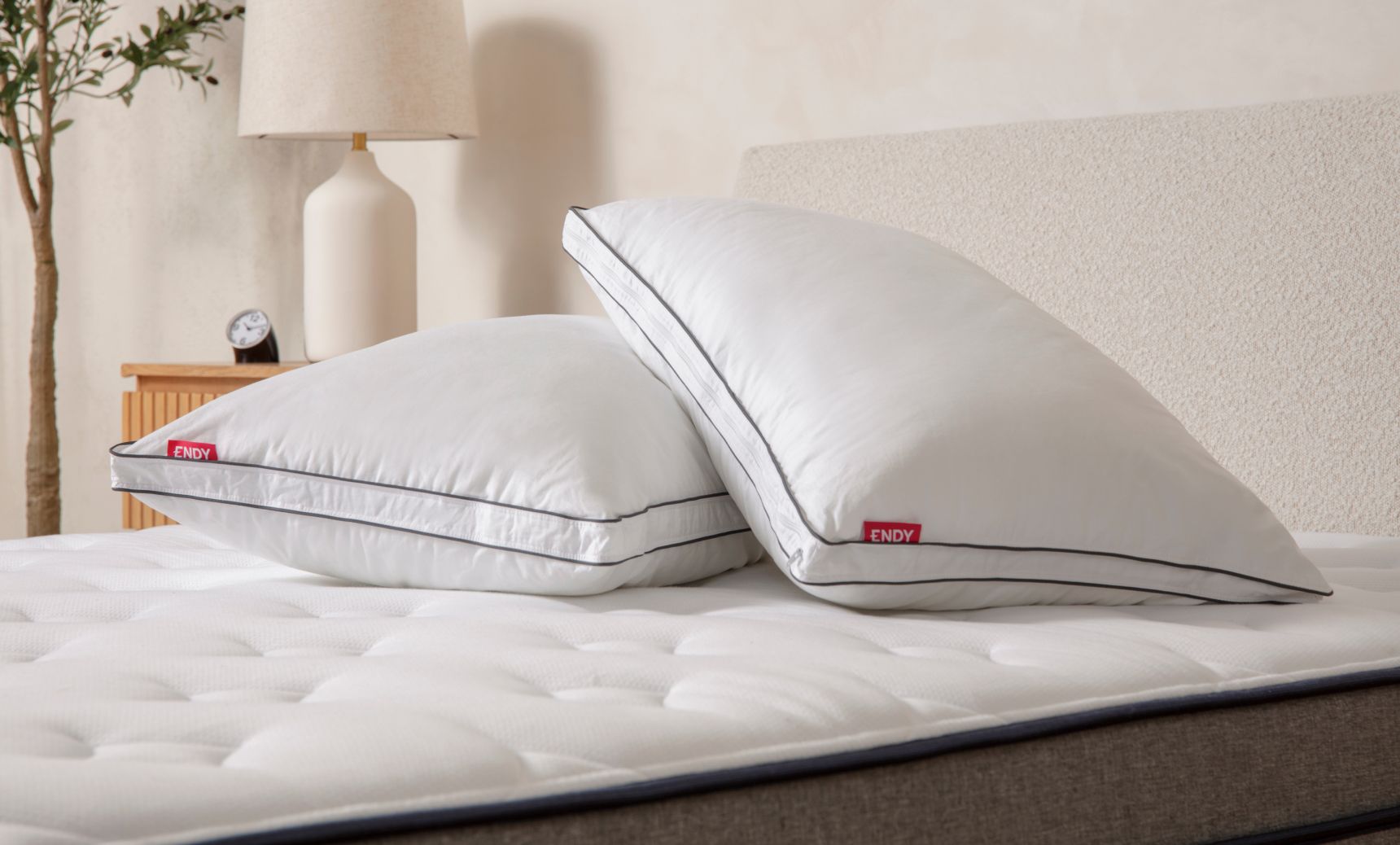 2 Endy Customizable Pillows lay on top of a bare Endy Mattress, one pillow slightly on top of the other