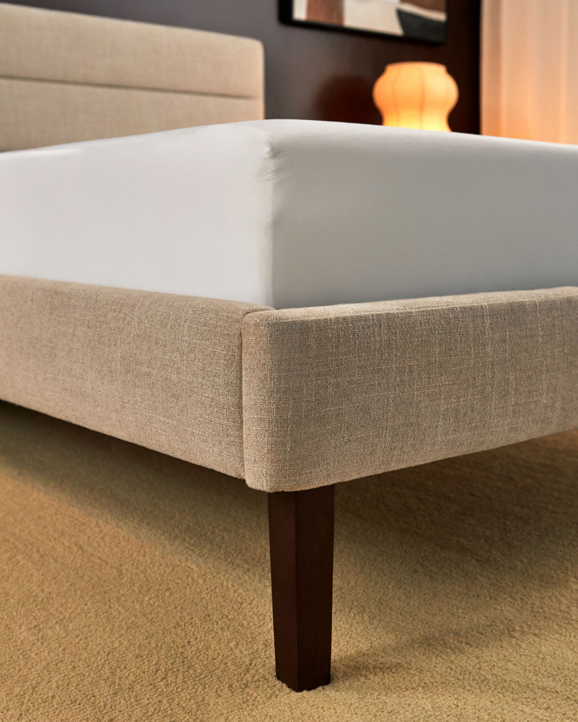 Close up detail shot of channel upholstered bed frame in alabaster colourway supporting the Endy Mattress.
