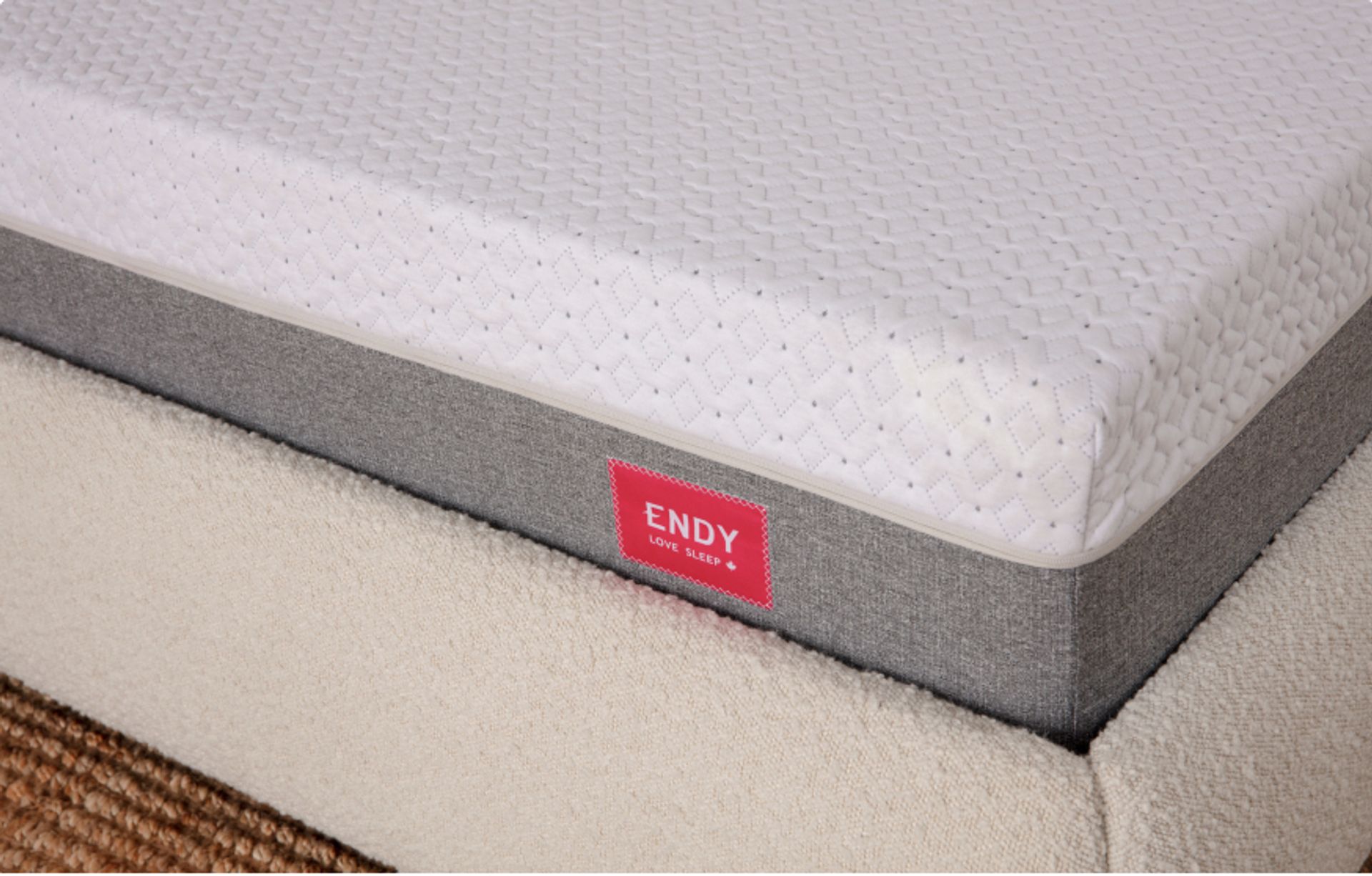 Close up of the corner of an Endy Mattress on a white upholstered bed frame