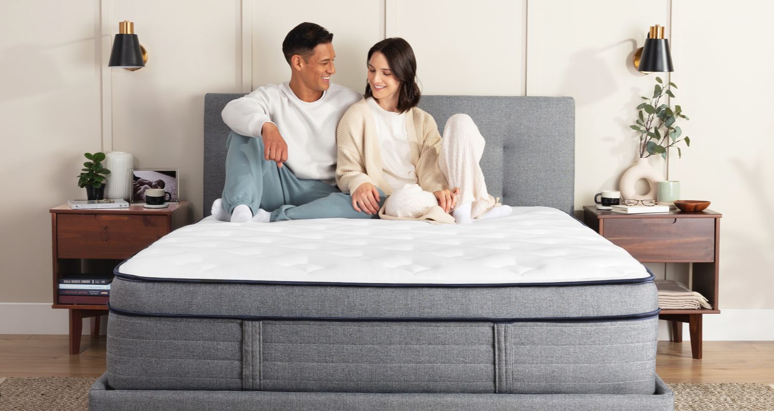 A couple sitting up on an Endy Hybrid Mattress.