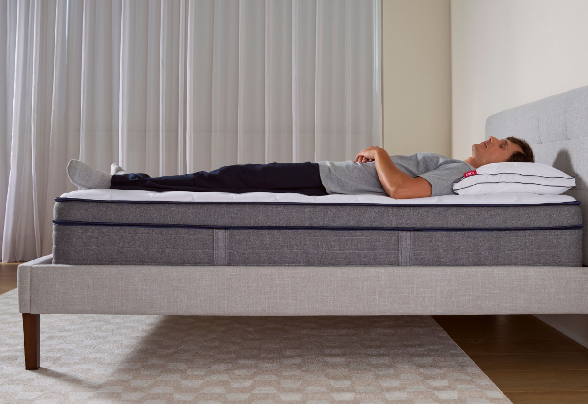 Man sleeping on his back on a bare Endy Elevate Hybrid