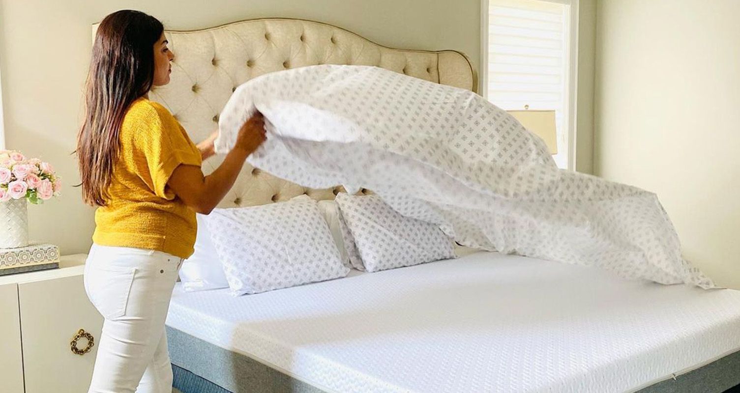 A woman putting clean sheets on her Endy Mattress