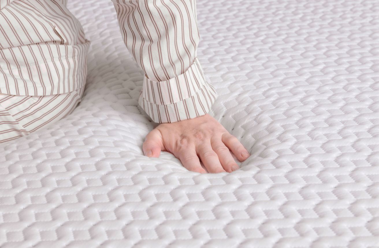 Main pressant le matelas Endy pour montrer la réactivité de la mousse