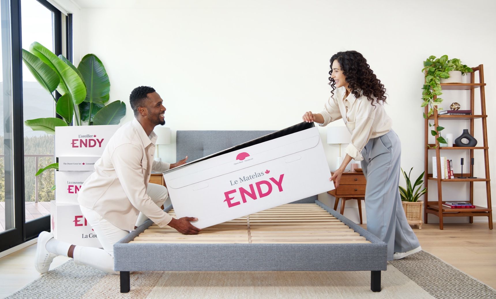 Two people holding The Endy Mattress in a box