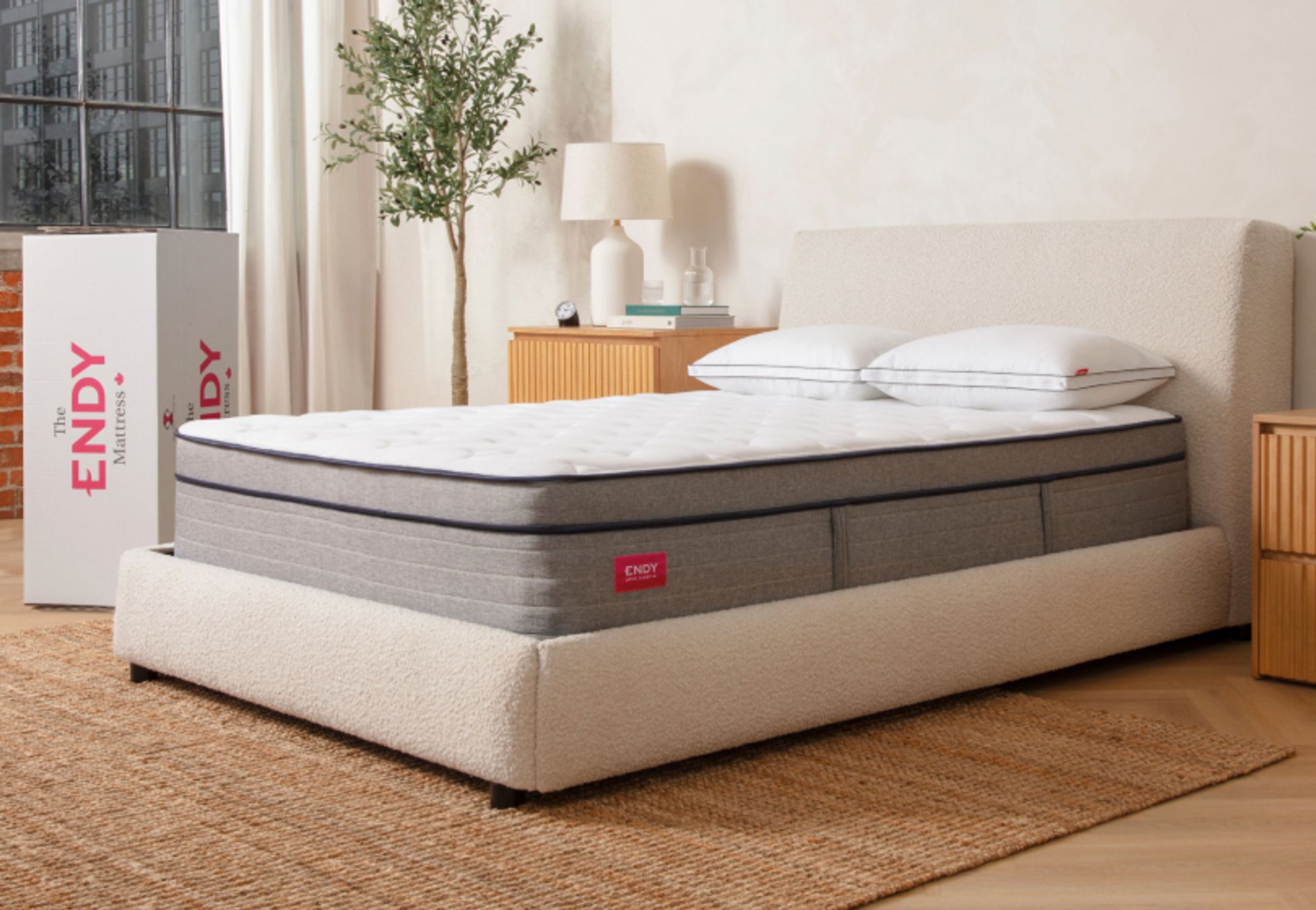 Bare Endy Hybrid mattress on a white upholstered bed frame in a beige bedroom