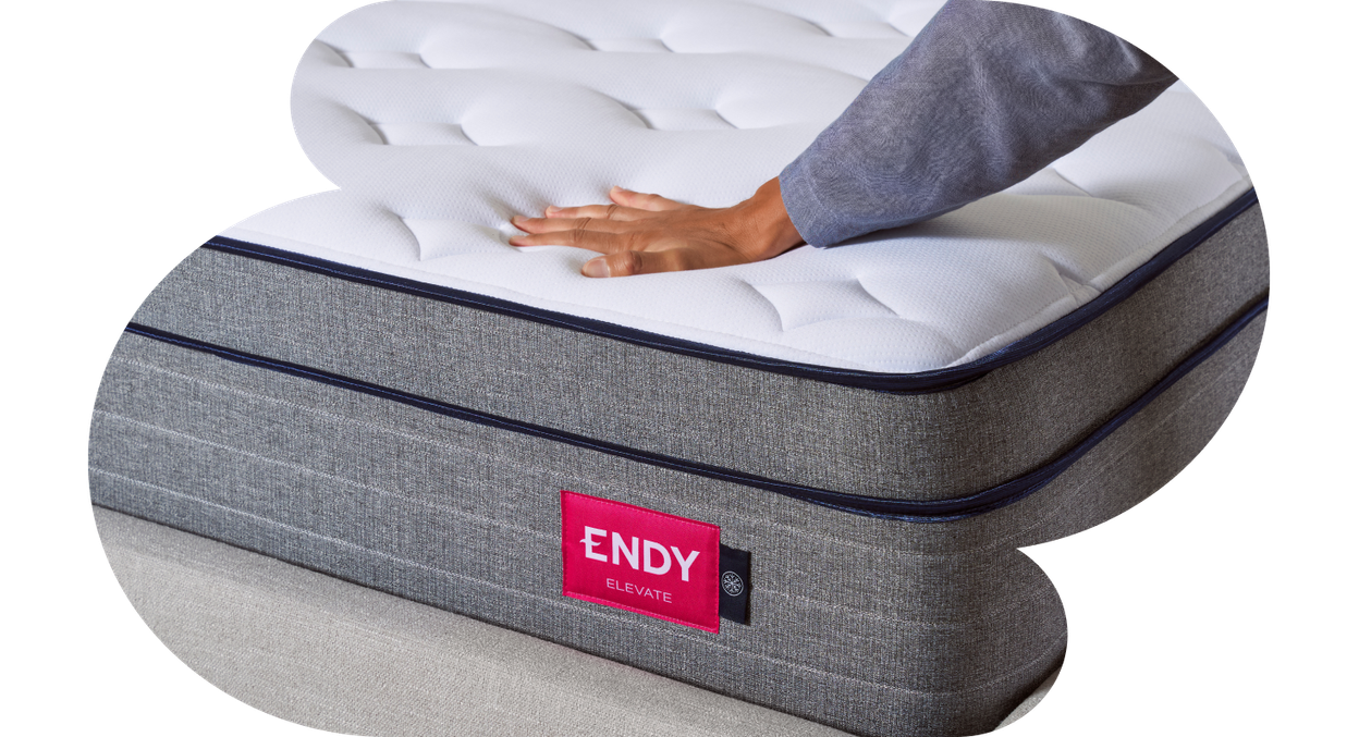  A person's hand resting on the Endy Hybrid Mattress.
