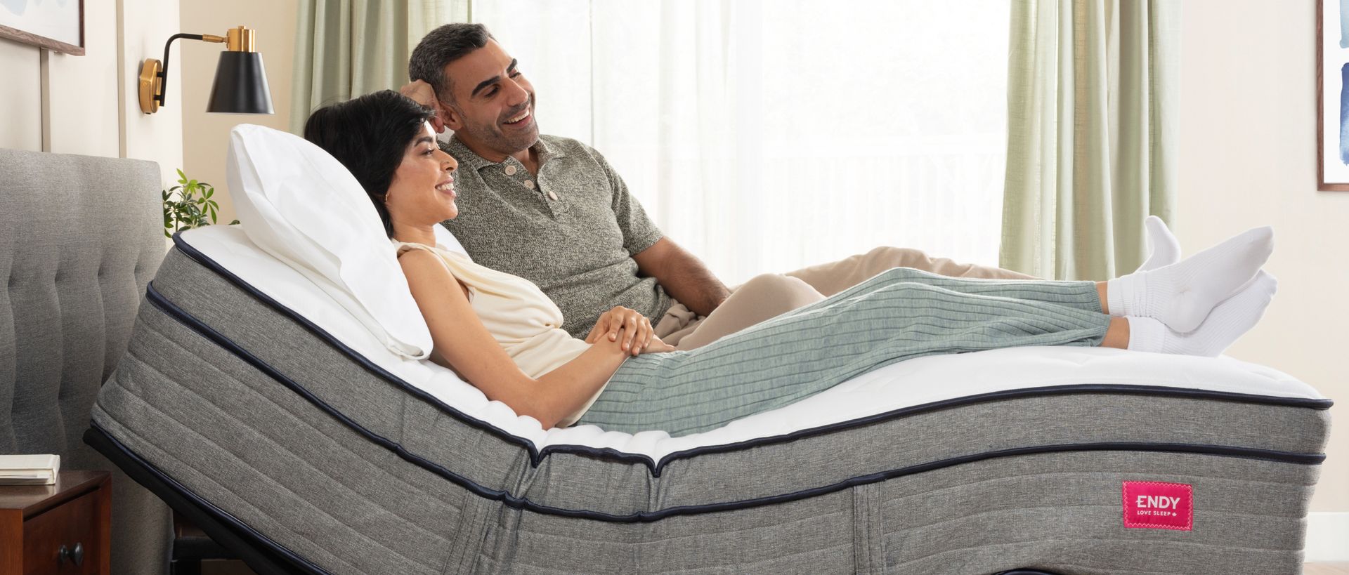 Man and woman lying on an inclined adjustable bed