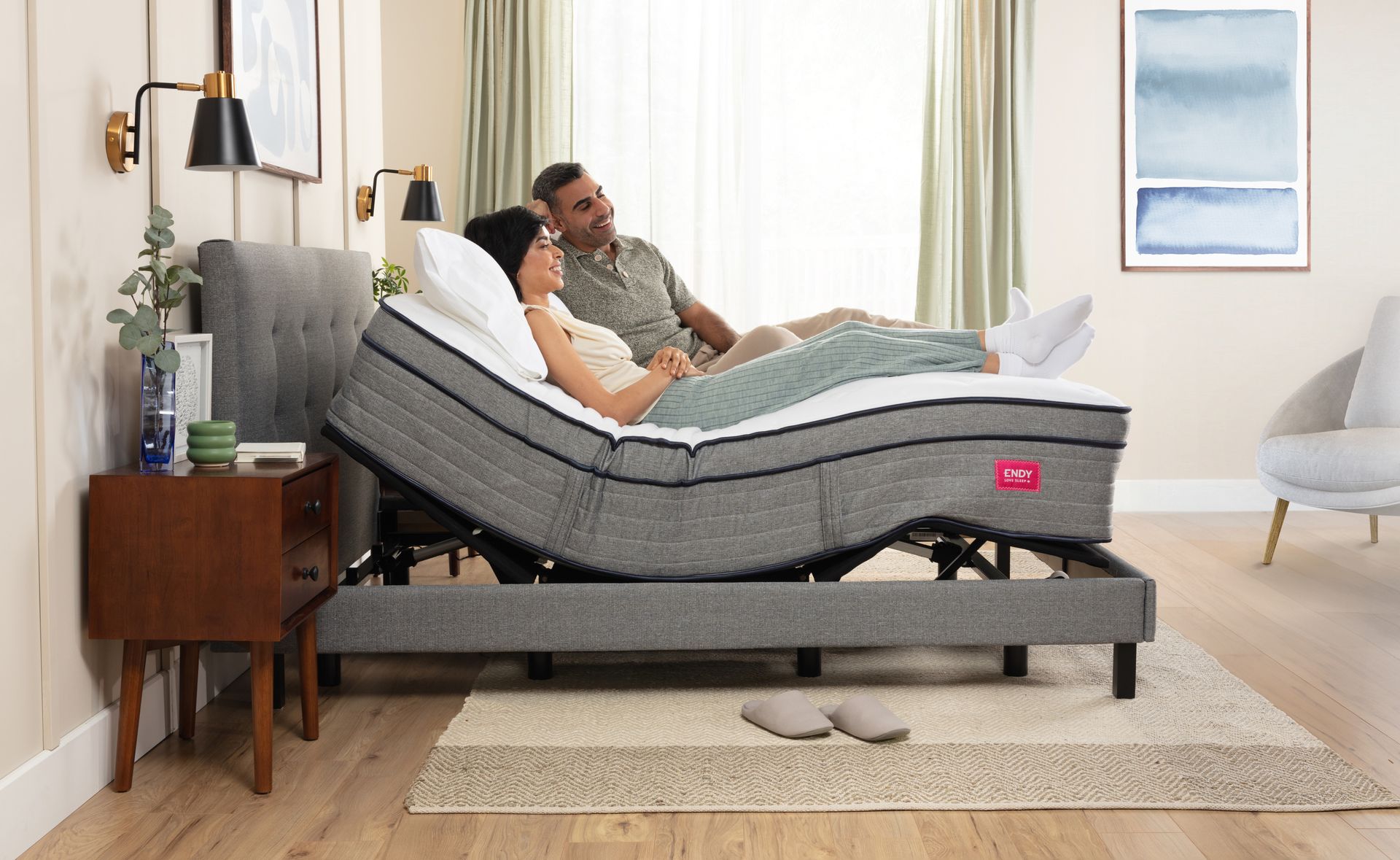 Man and woman lying on an adjustable bed, sitting up at a 45 degree angle