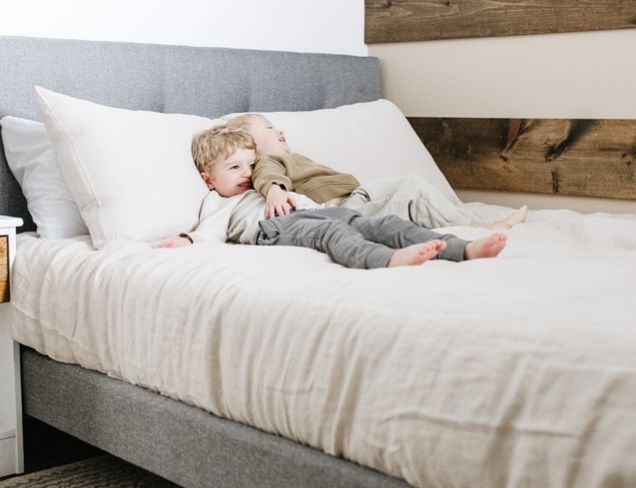 Two children lying down on an Endy Upholstered Bed