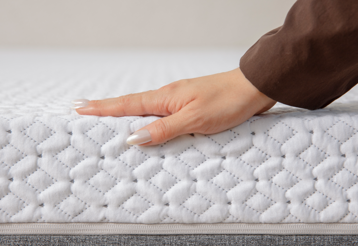 Hand showing the mattress sink of the Medium-Firm Endy Mattress variant.