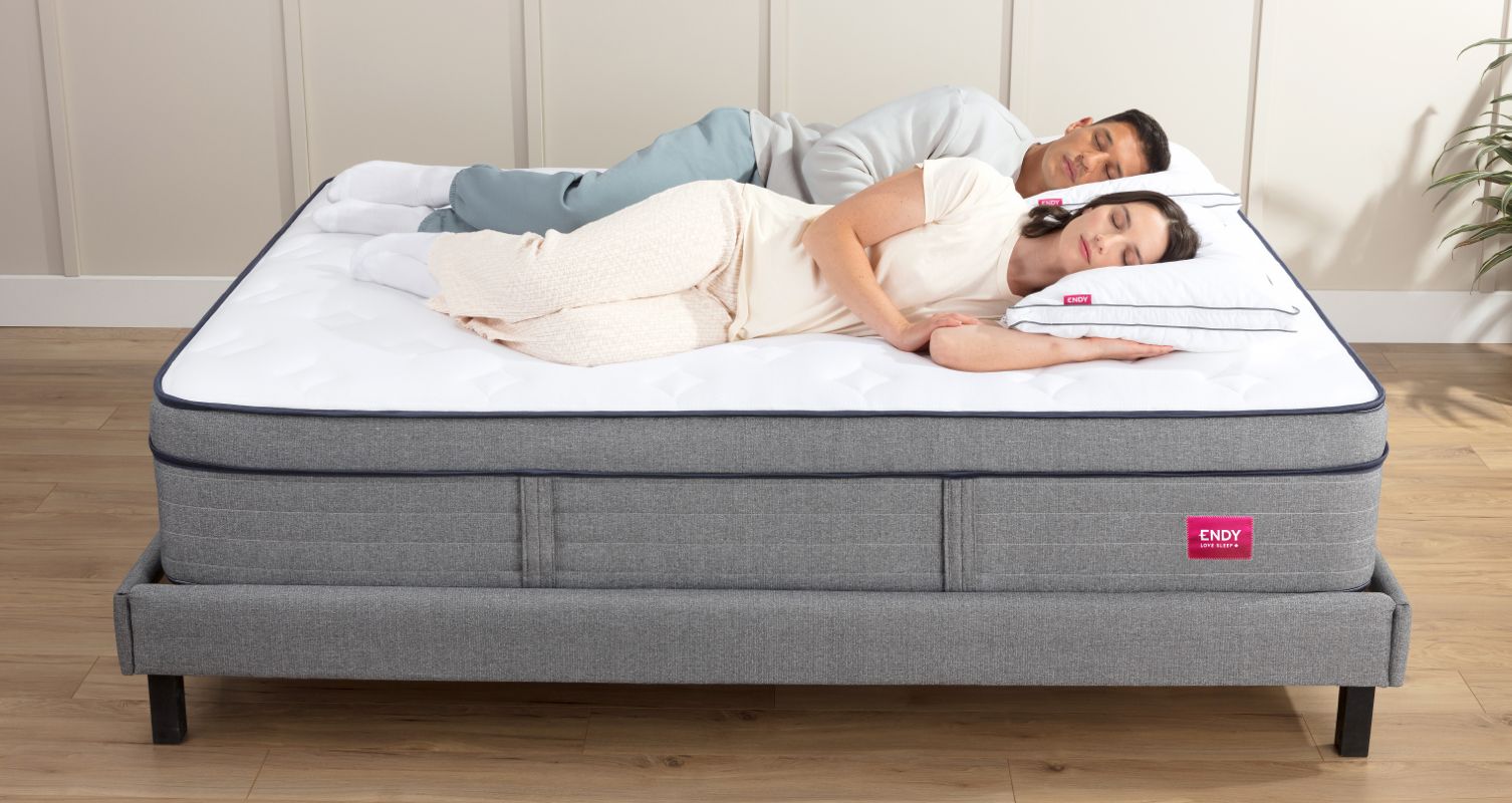 A couple laying next to each other on their sides, on an Endy Hybrid Mattress.