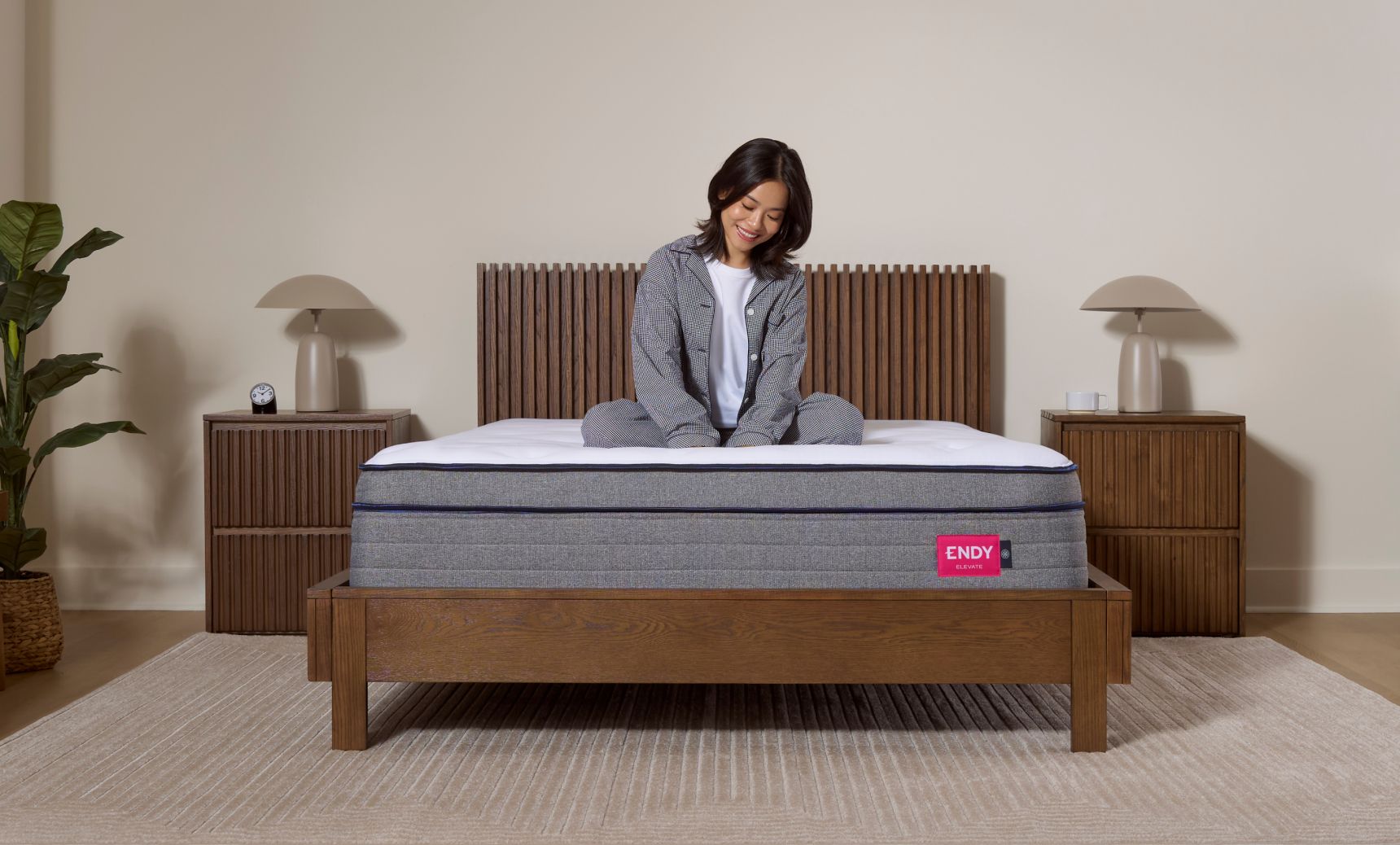 Woman sitting cross-legged on an Endy Elevate Hybrid mattress