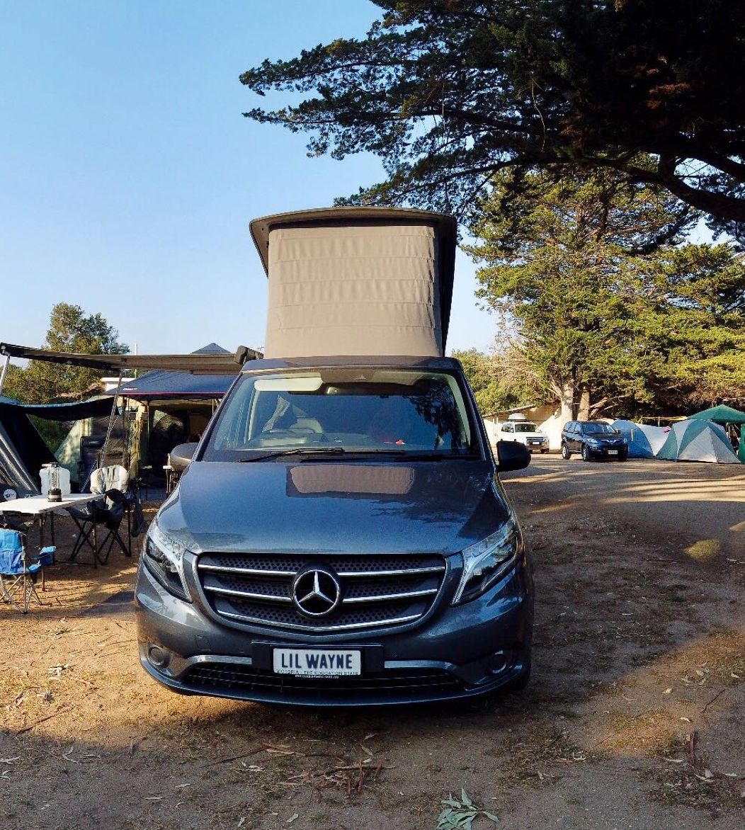 Our campervan Lil Wayne, with top popped, at a camping site.