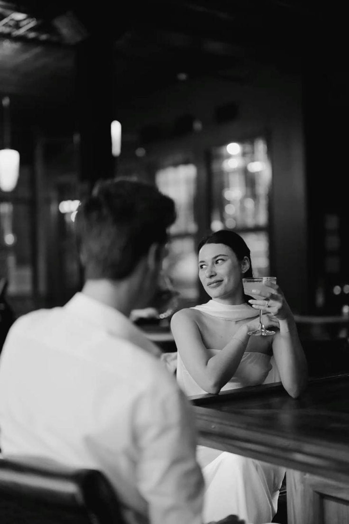 A woman smiling at her partner across a dim bar