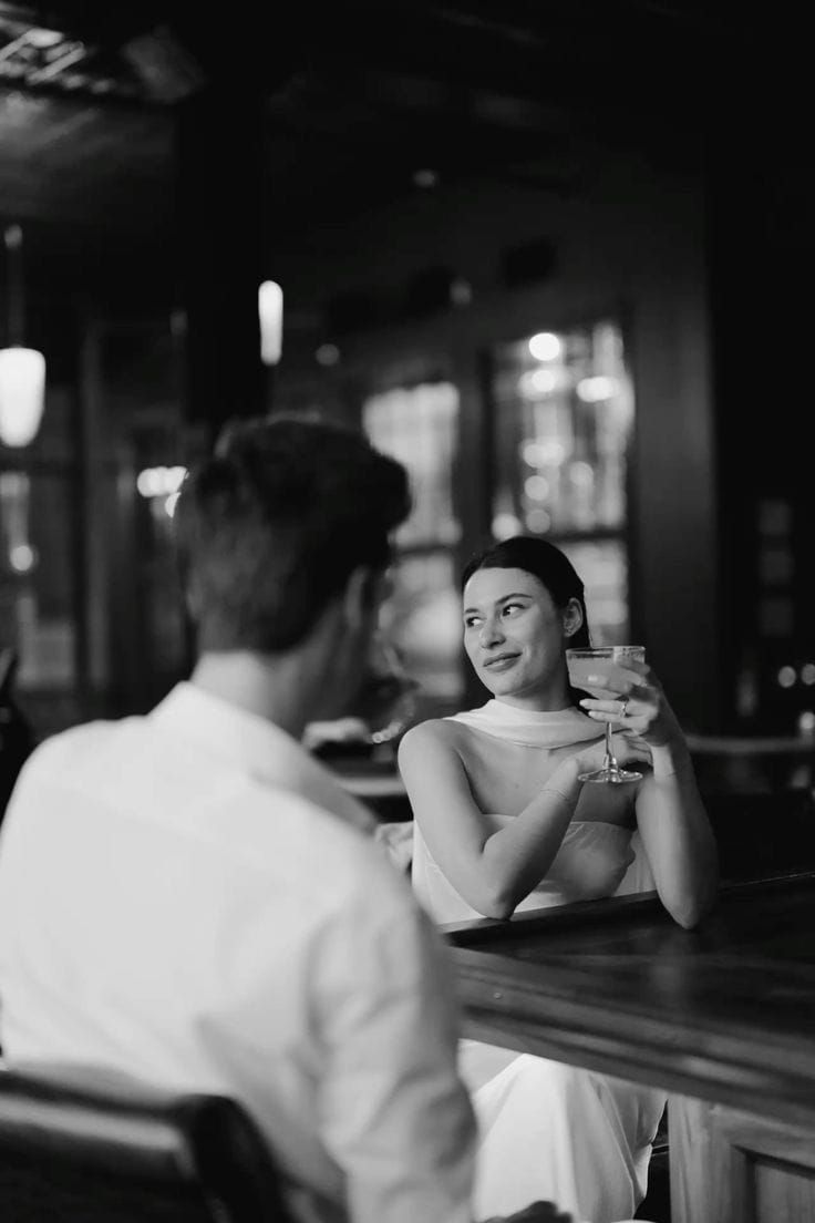 A woman smiling at her partner across a dim bar