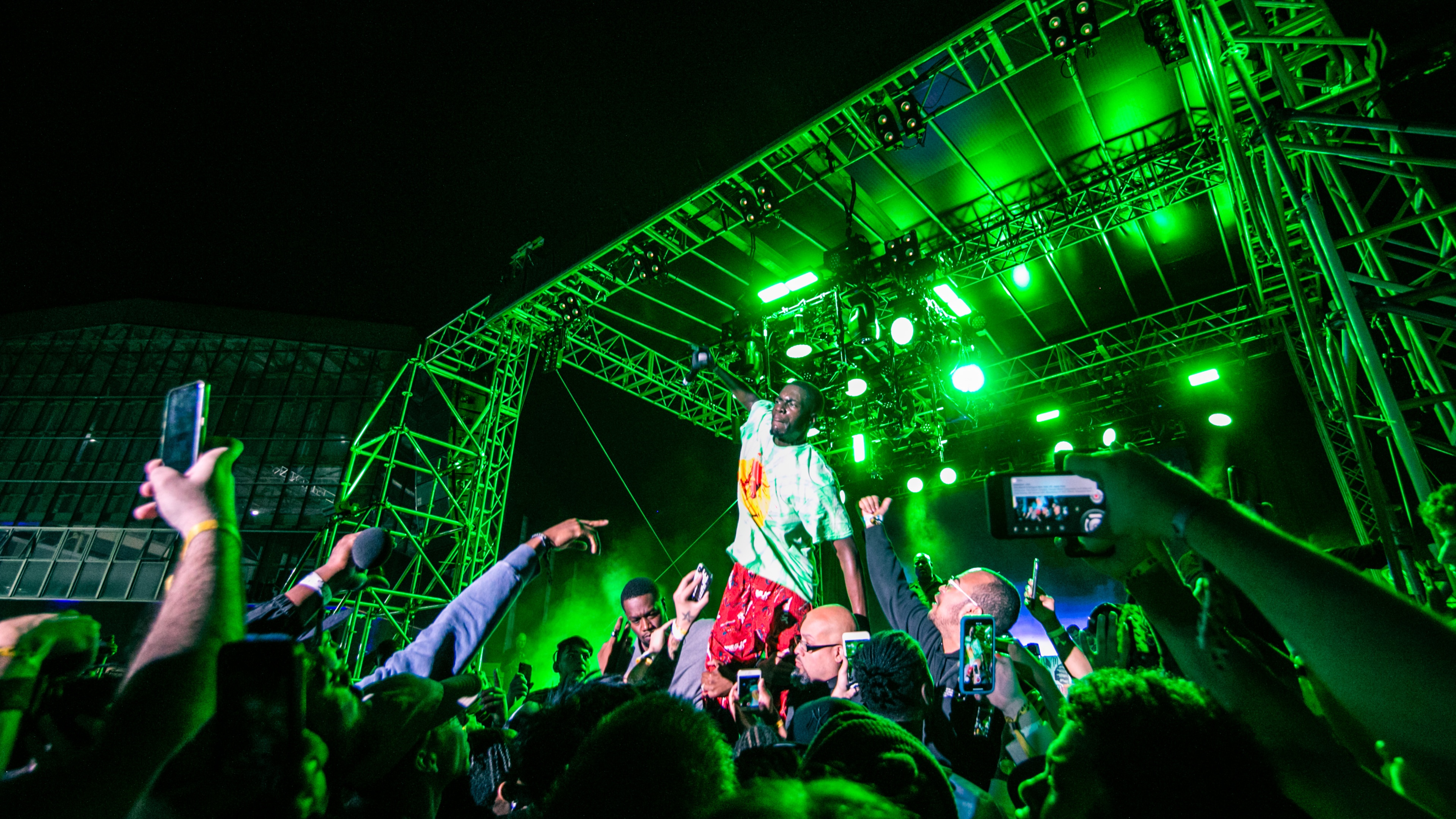 Man on stage performing at HYPEFEST with green lighting