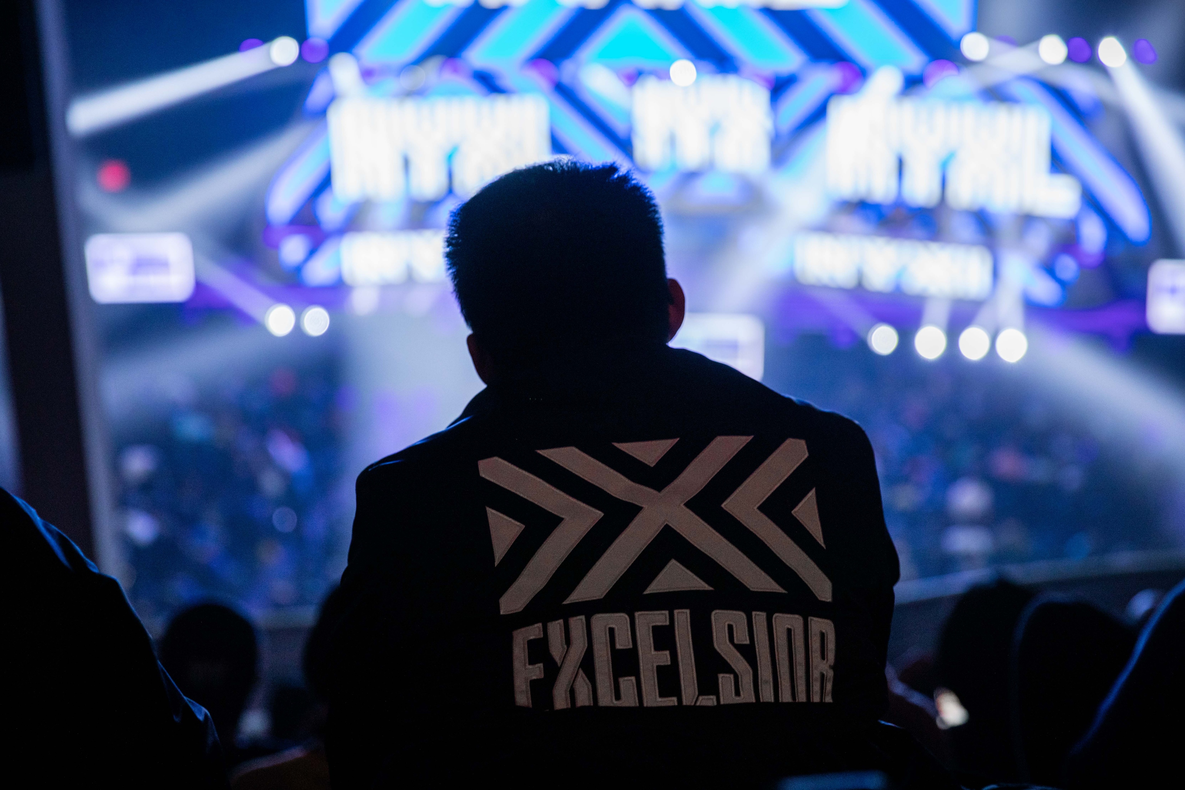 Man wearing Excelsior jacket watching competition