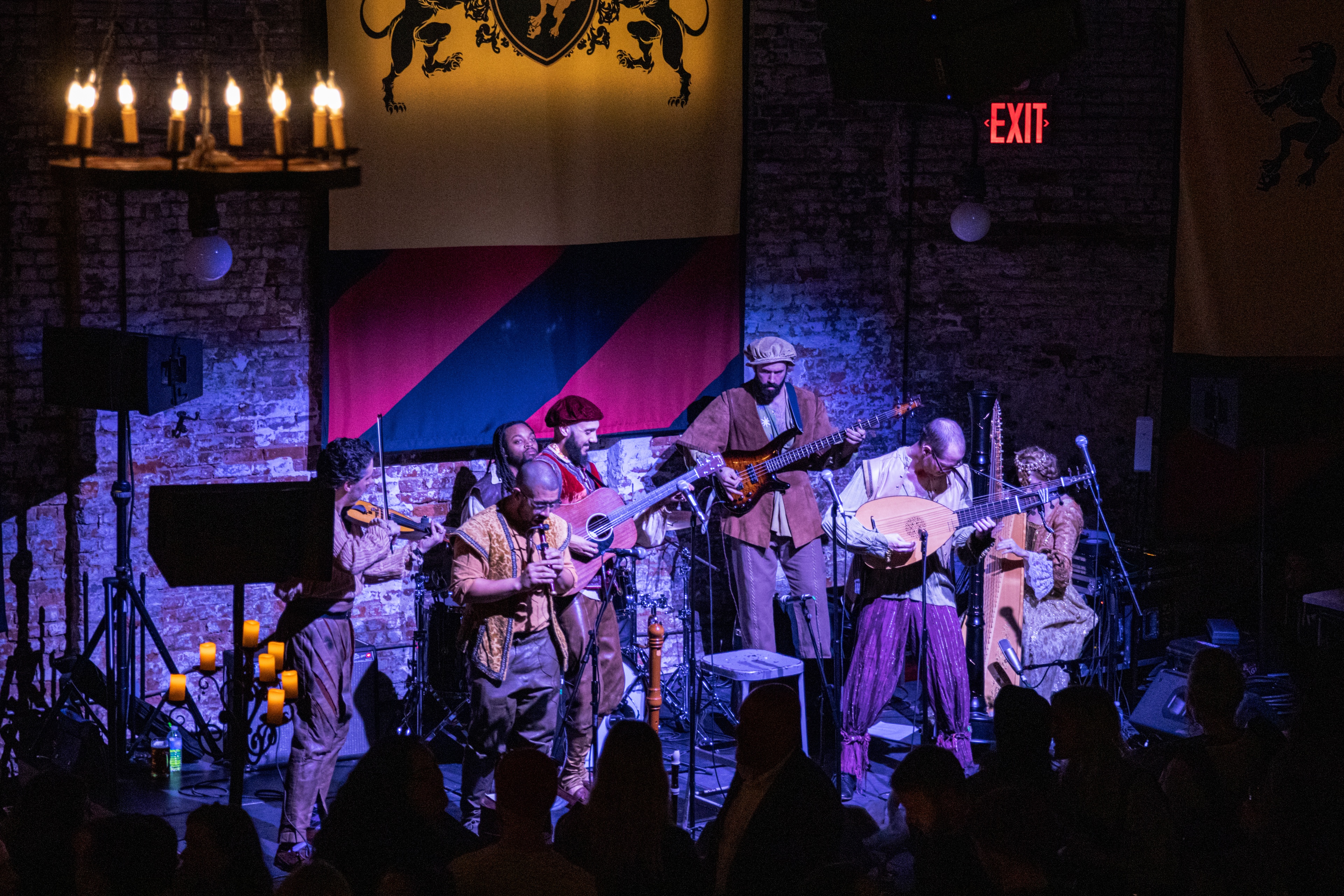 Band in medieval clothing performing on stage in blue lighting