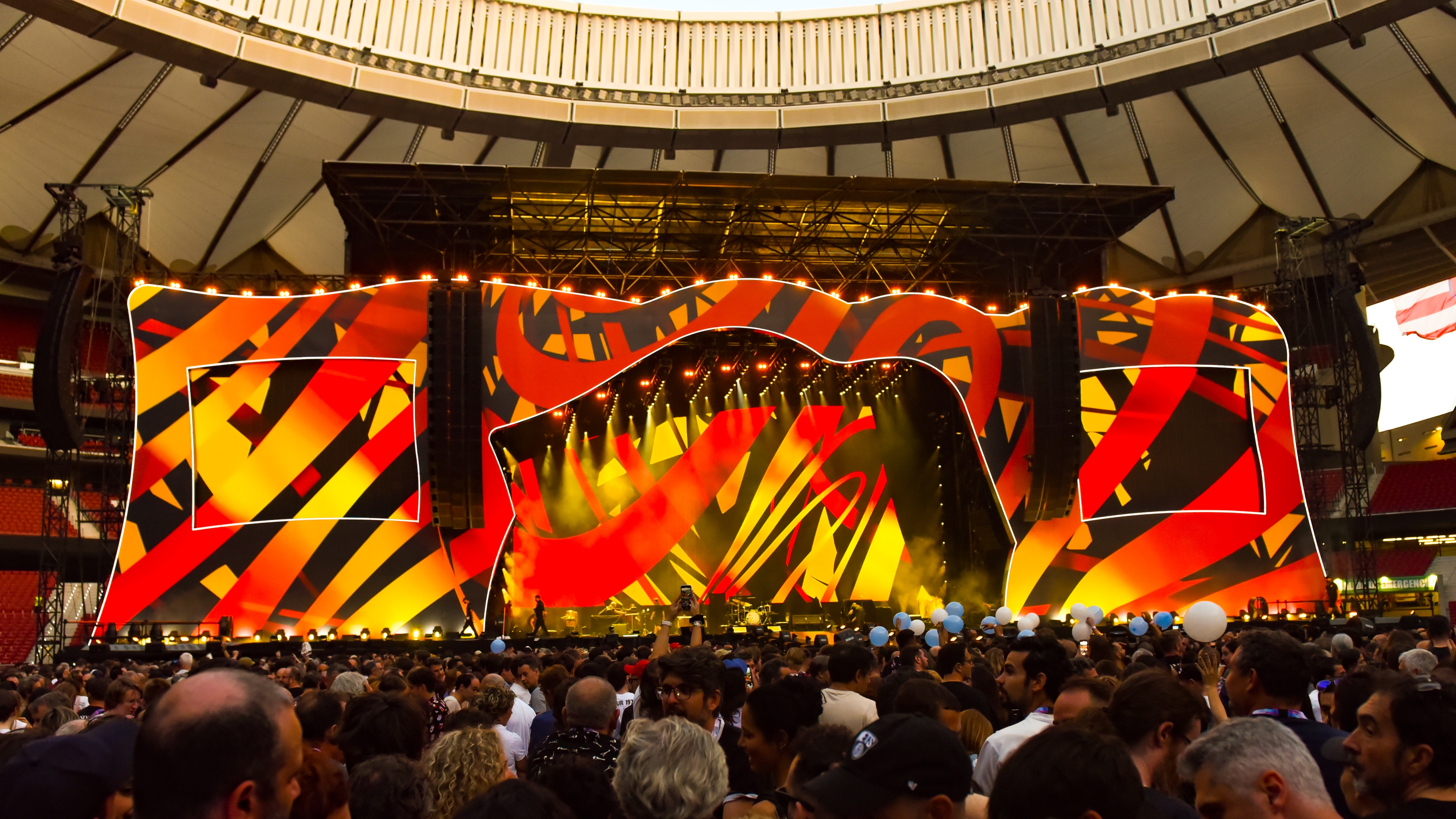 Huge stage design for The Rolling Stones in football stadium with red and yellow design and crowd