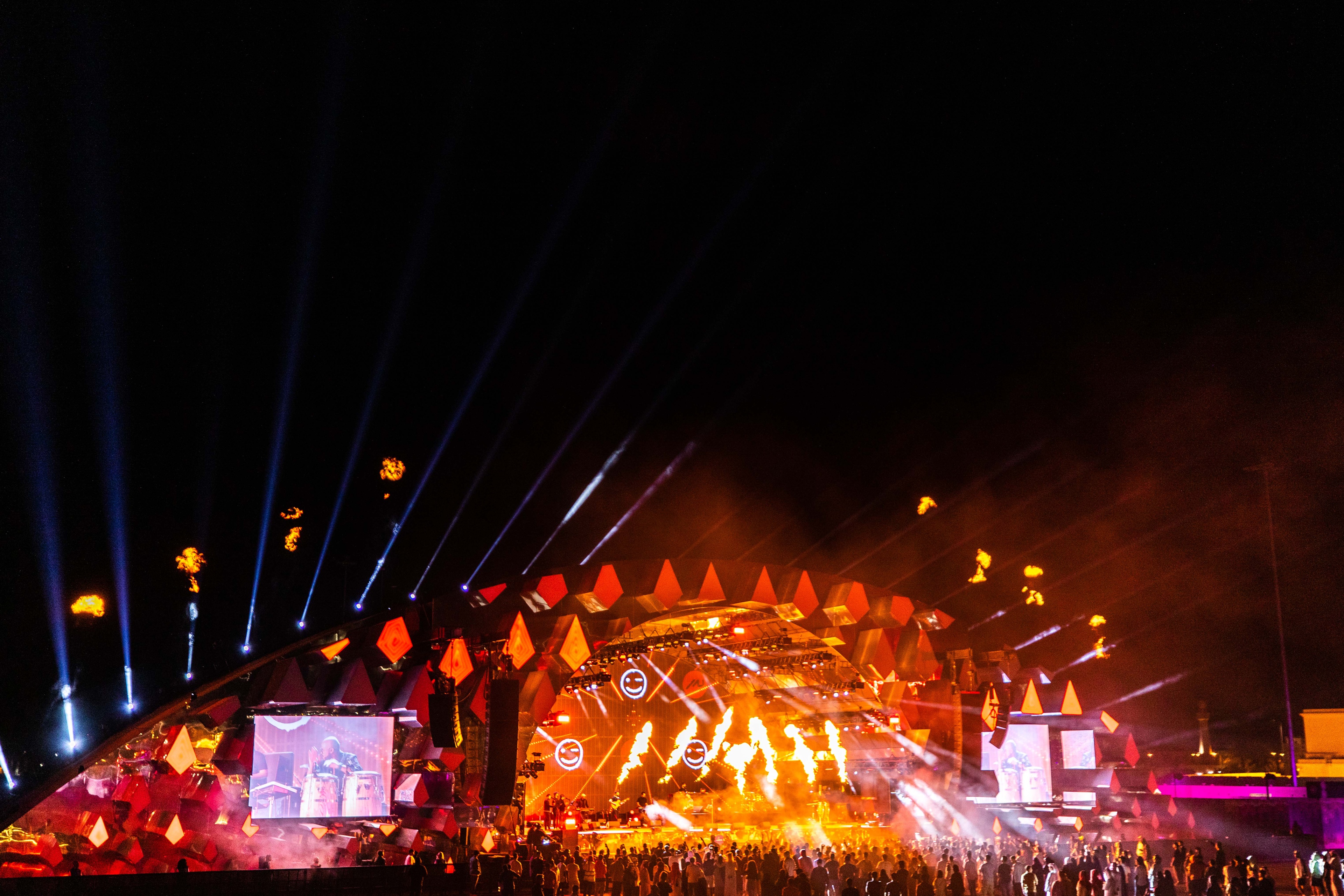 far view of Aravia MDLBEAST stage and crowd, bright orange and yellow lights