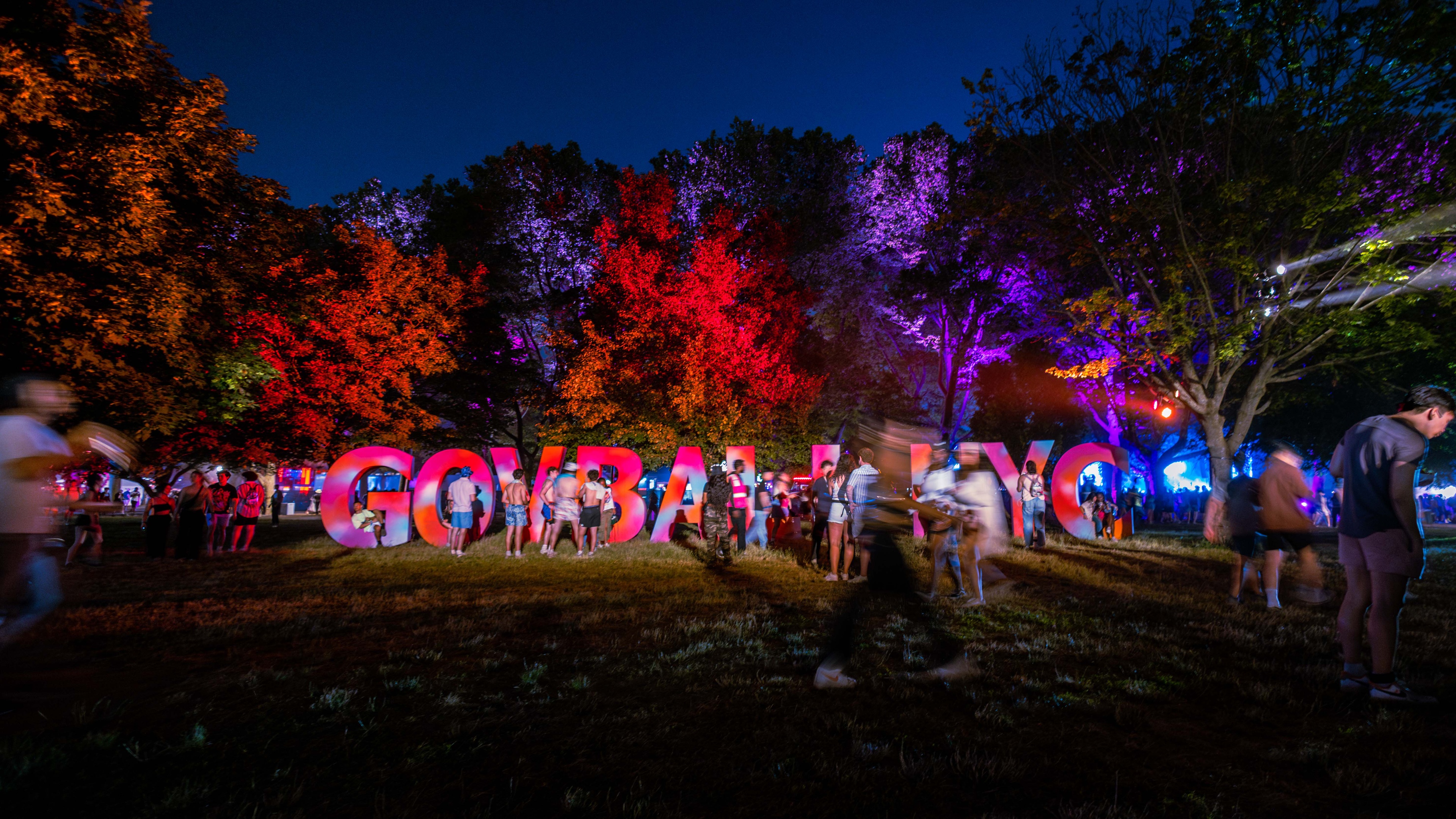 Founders Entertainment The Governors Ball at night, attendees walking past a GOV BALL NYC red sign made out of 3D letters
