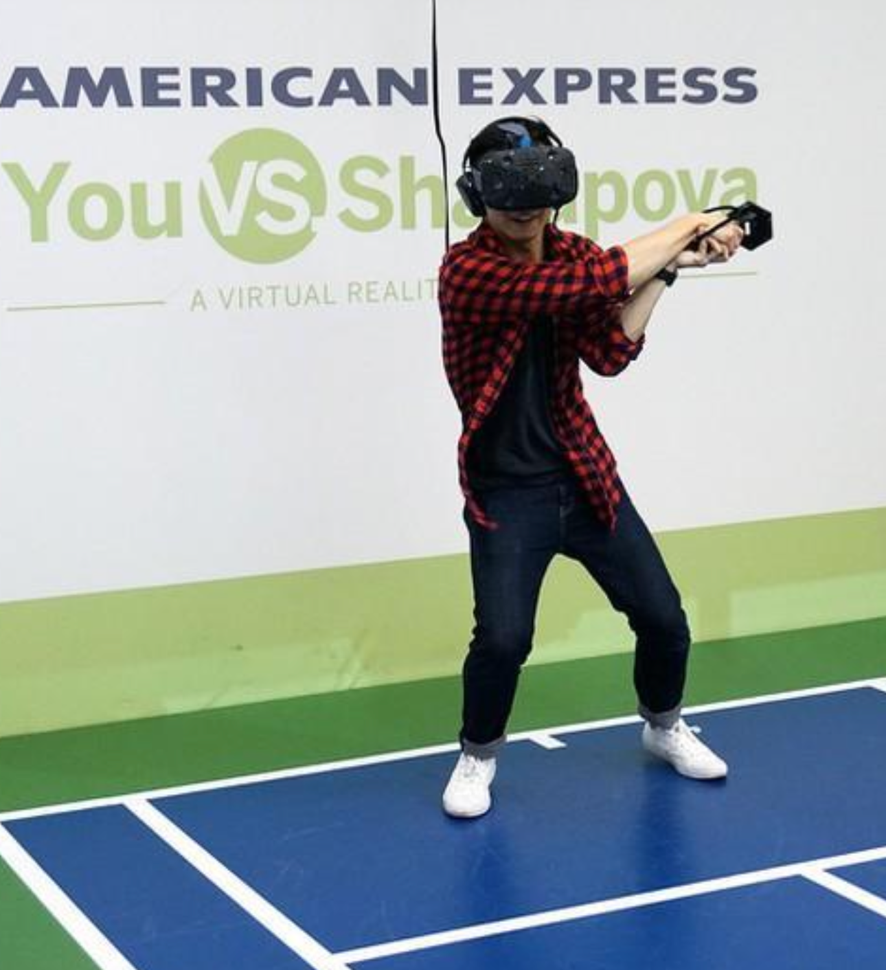 Man in red plaid shirt wearing virtual headset and playing tennis