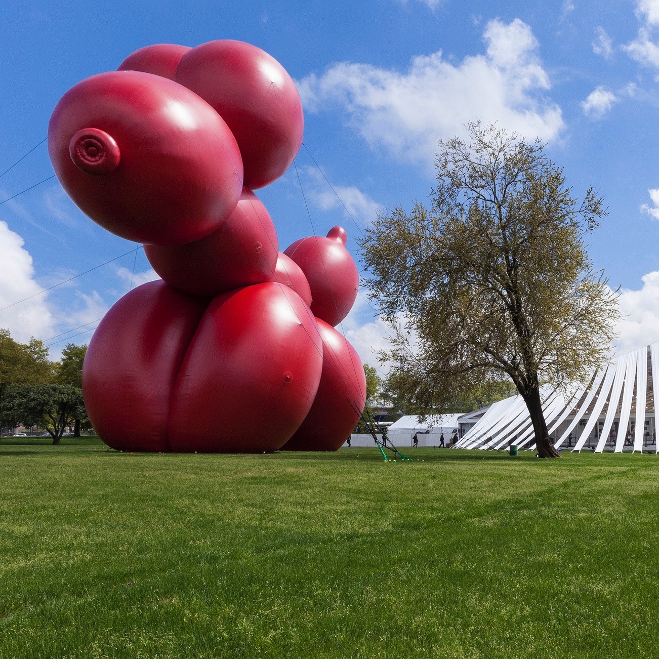 Giant red balloon animal dog in front of large tent