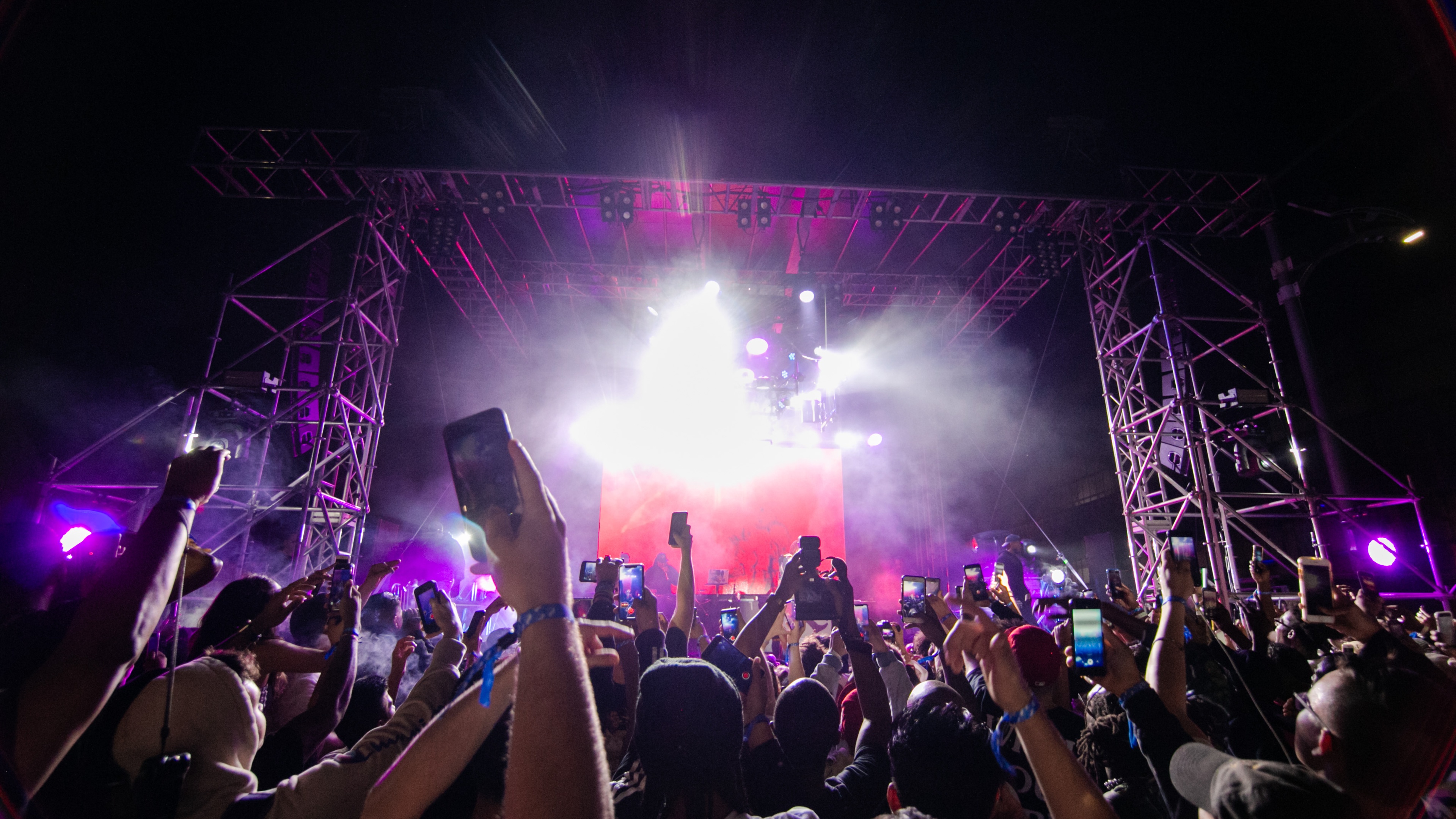 HYPEFEST crowd cheering during night time performance with pink lighting