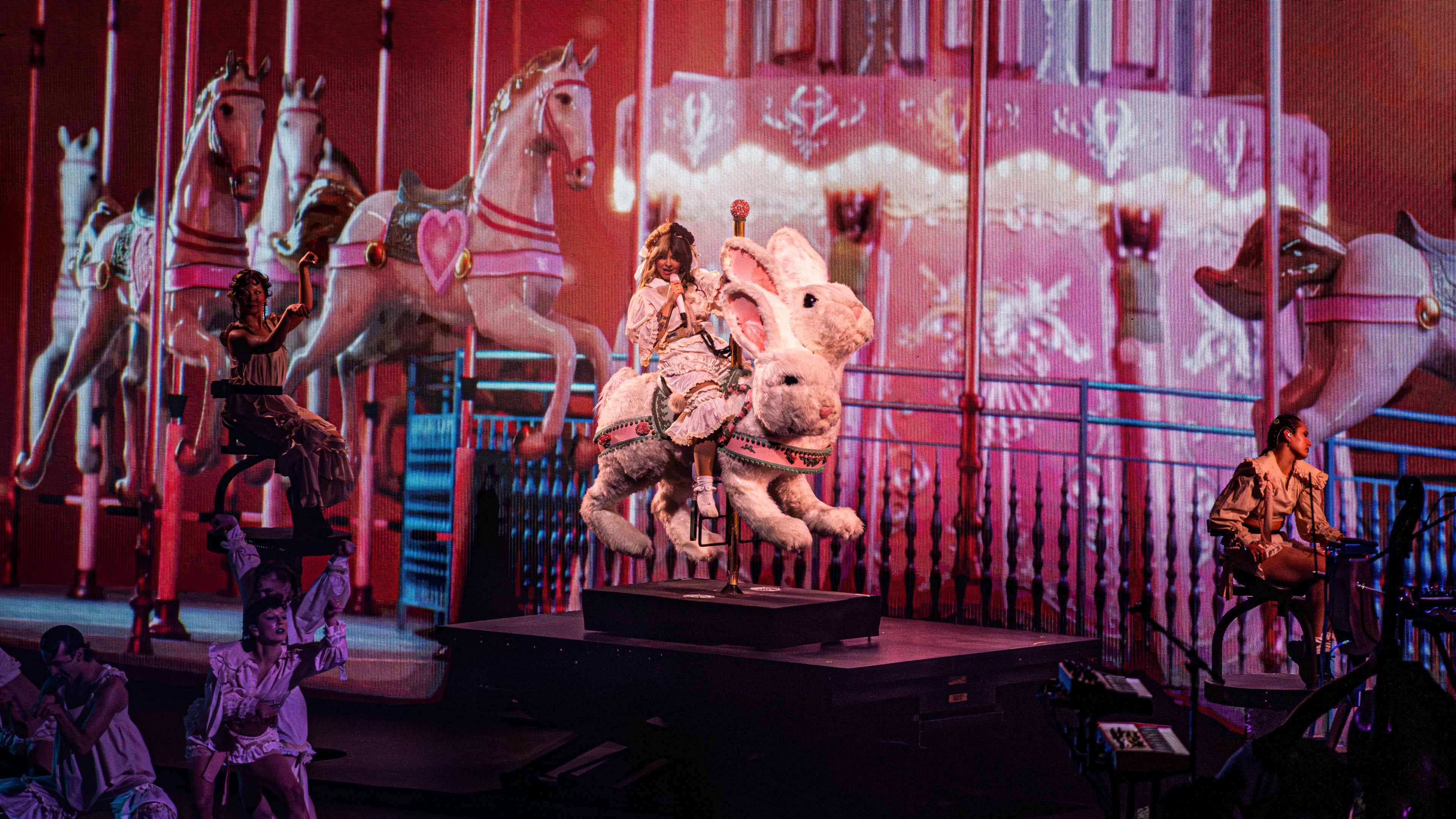 Stage with carousel and bunnies with pink lighting